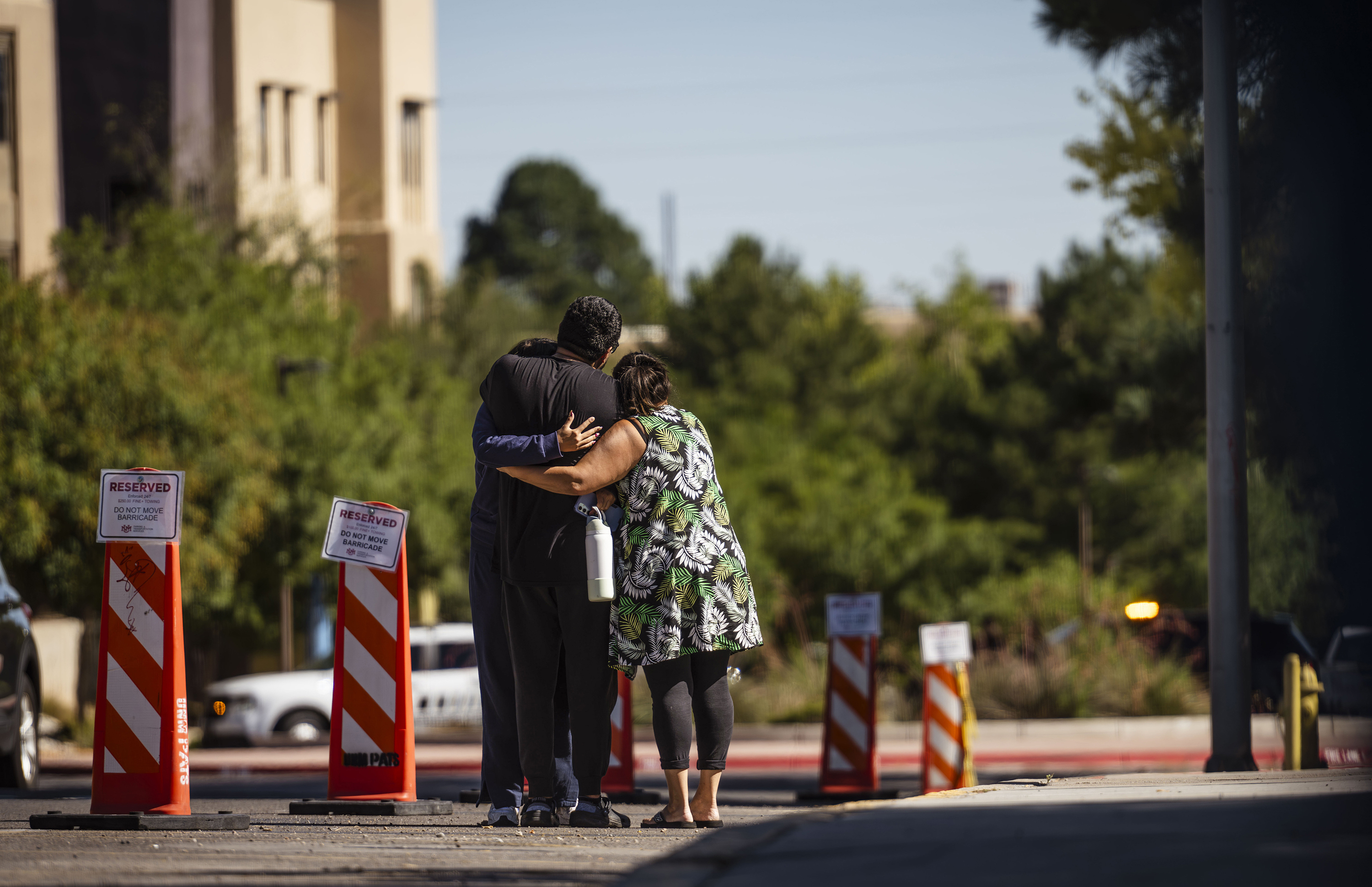 Family members embrace at the University of New Mexico Central Campus after a deadly shooting at Casas del Rio (Gila), a student housing center, early Friday, July 25, 2025 in Albuquerque, N.M. (Chancey Bush/The Albuquerque Journal via AP)