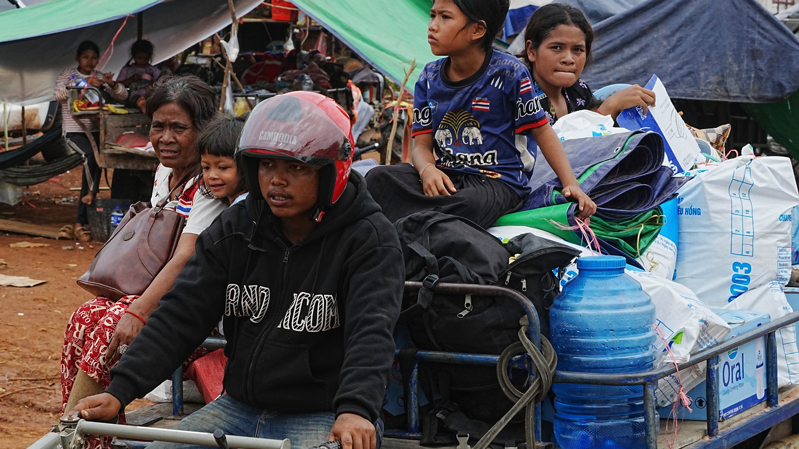 Cambodians sit on a tractor cart as they take refuge in Batthkoa primary school in Oddar Meanchey province, Cambodia, Saturday, July 26, 2025, as border fighting between Thailand and Cambodia entered its third day. (AP Photo/Heng Sinith)
