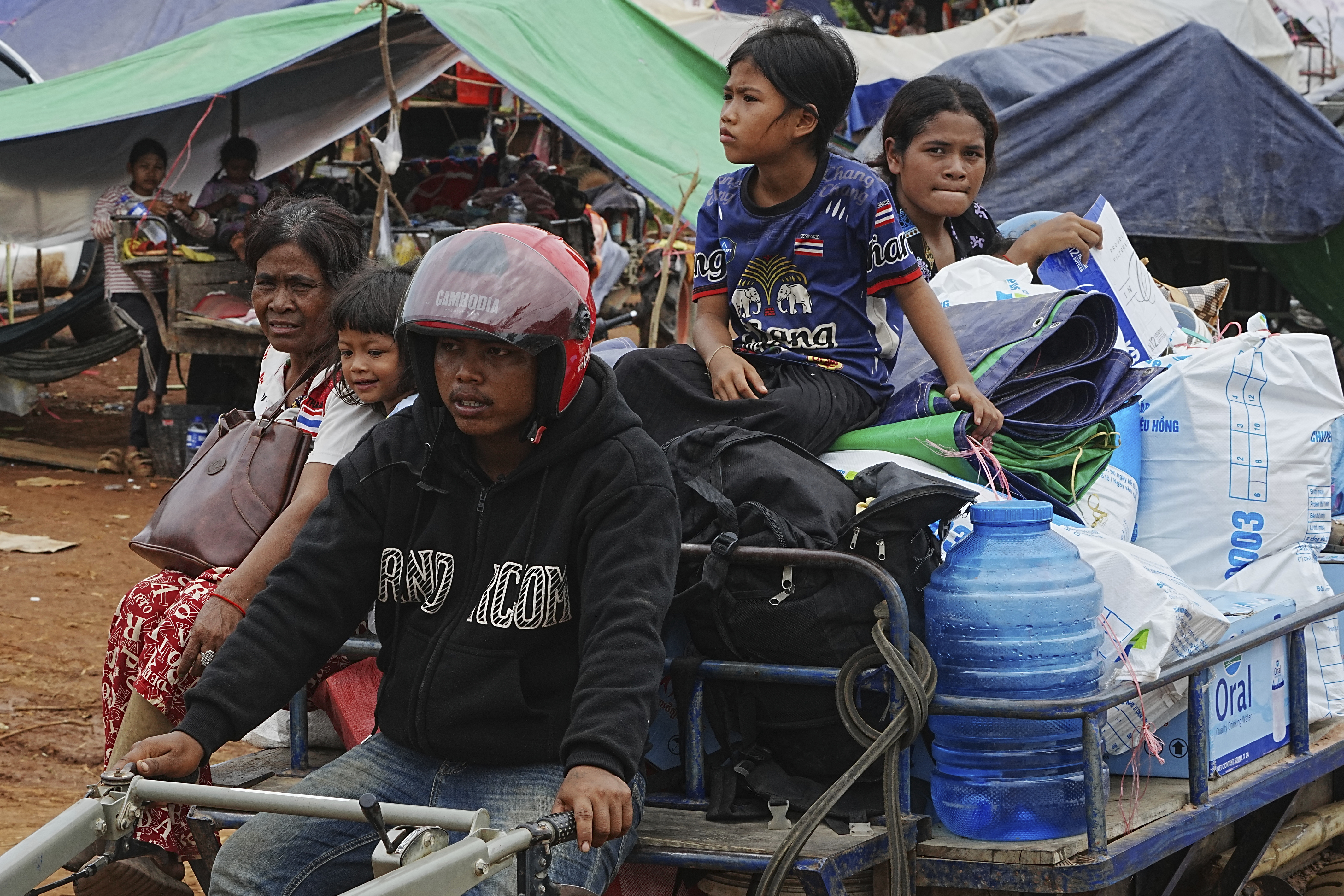 Cambodians sit on a tractor cart as they take refuge in Batthkoa primary school in Oddar Meanchey province, Cambodia, Saturday, July 26, 2025, as border fighting between Thailand and Cambodia entered its third day. (AP Photo/Heng Sinith)