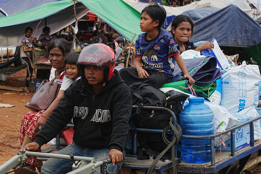 Cambodians sit on a tractor cart as they take refuge in Batthkoa primary school in Oddar Meanchey province, Cambodia, Saturday, July 26, 2025, as border fighting between Thailand and Cambodia entered its third day. (AP Photo/Heng Sinith)