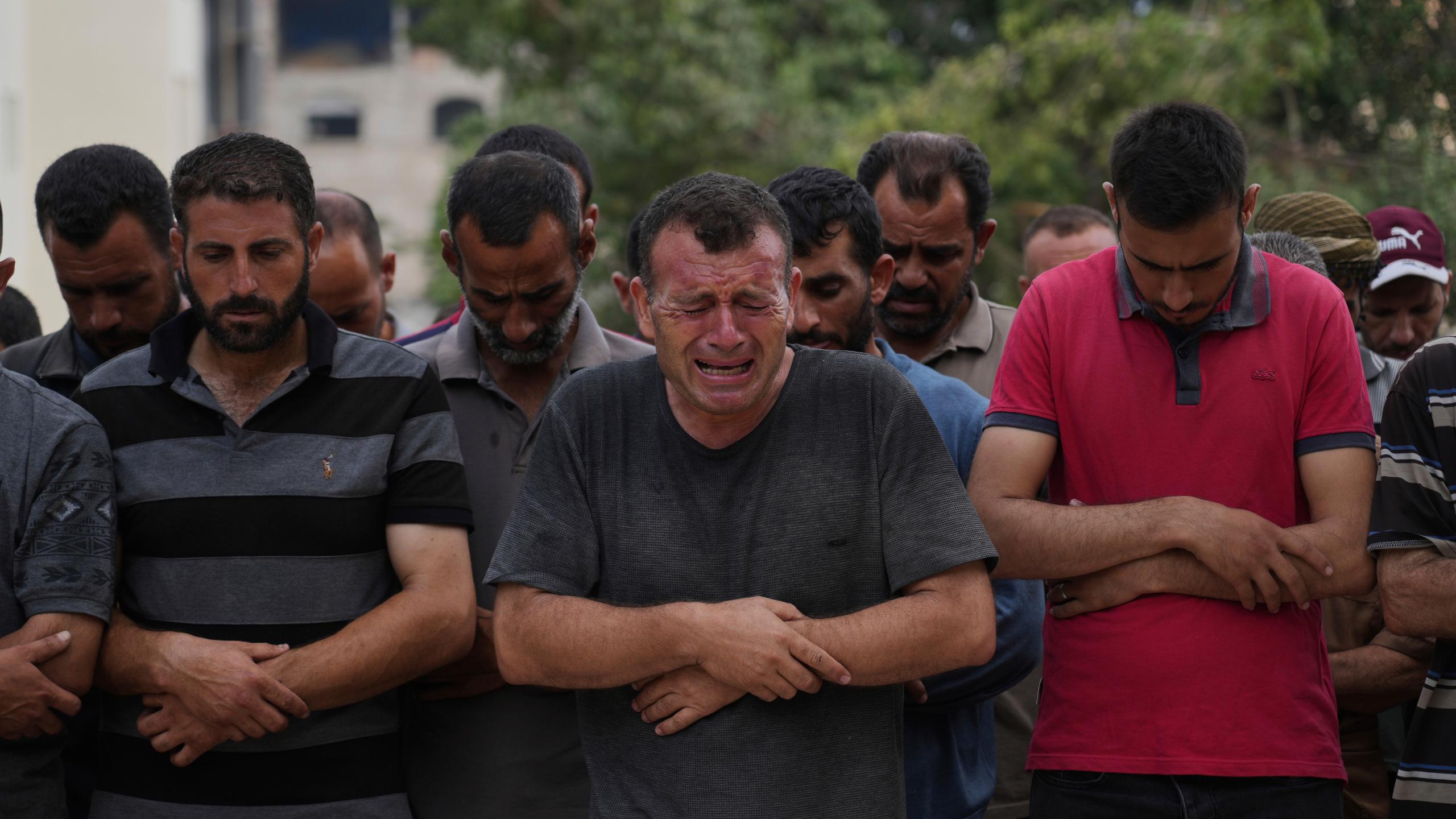 Palestinians pray over the body of a person who was killed while trying to reach aid trucks entering northern Gaza through the Zikim crossing with Israel, at Shifa Hospital, in Gaza City, Saturday, July 26, 2025. (AP Photo/Abdel Kareem Hana)