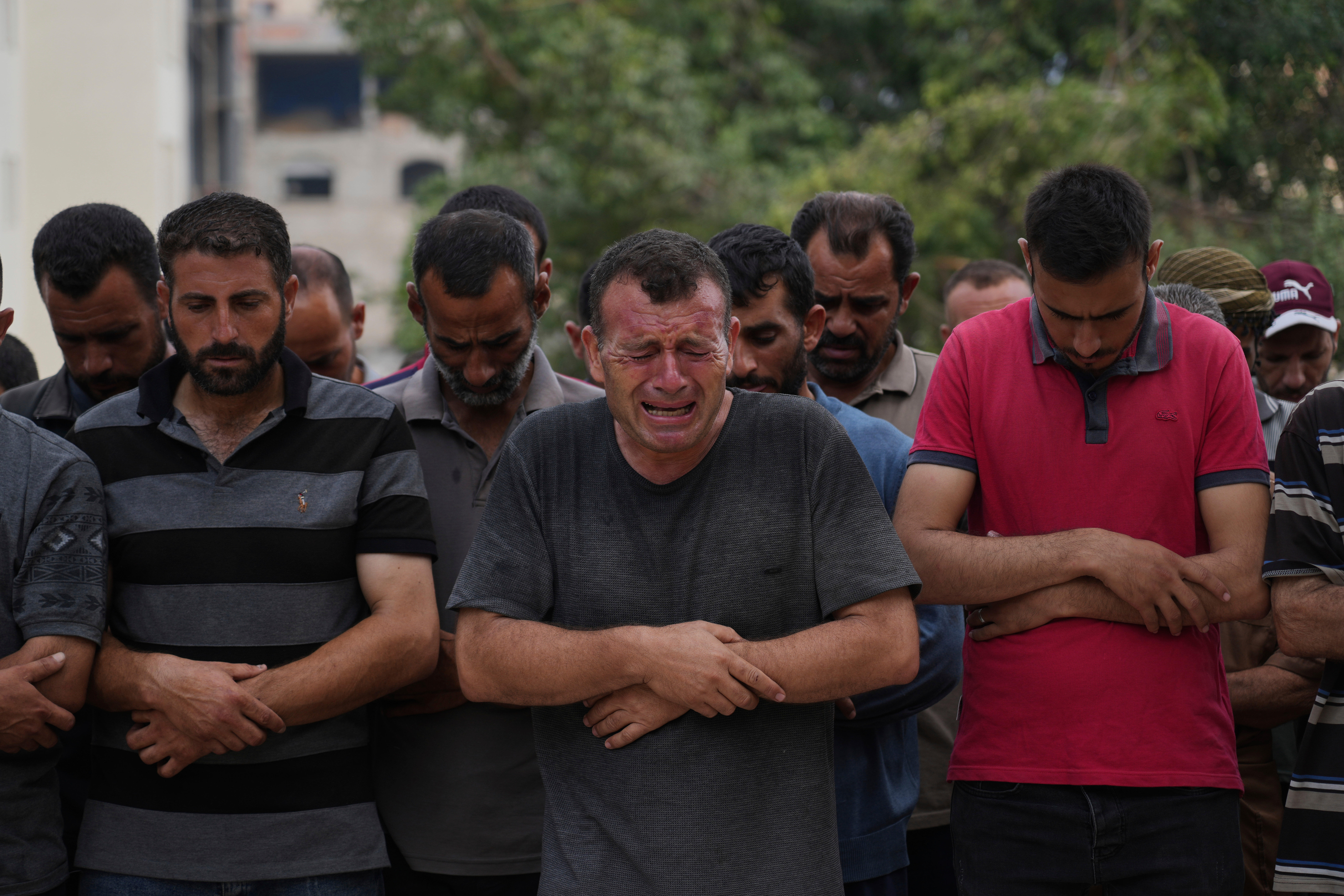 Palestinians pray over the body of a person who was killed while trying to reach aid trucks entering northern Gaza through the Zikim crossing with Israel, at Shifa Hospital, in Gaza City, Saturday, July 26, 2025. (AP Photo/Abdel Kareem Hana)