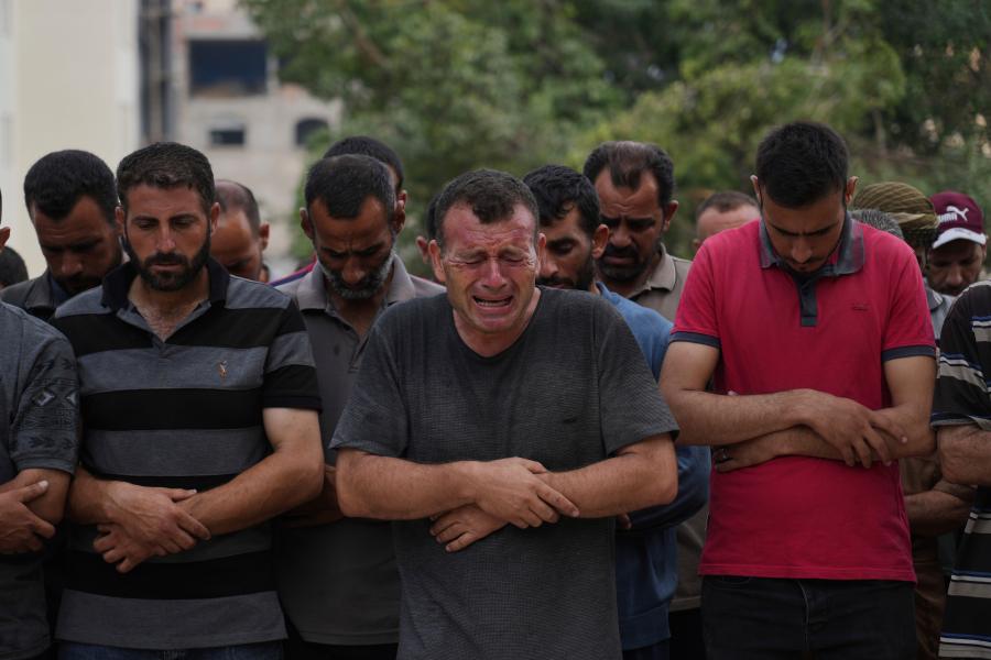 Palestinians pray over the body of a person who was killed while trying to reach aid trucks entering northern Gaza through the Zikim crossing with Israel, at Shifa Hospital, in Gaza City, Saturday, July 26, 2025. (AP Photo/Abdel Kareem Hana)