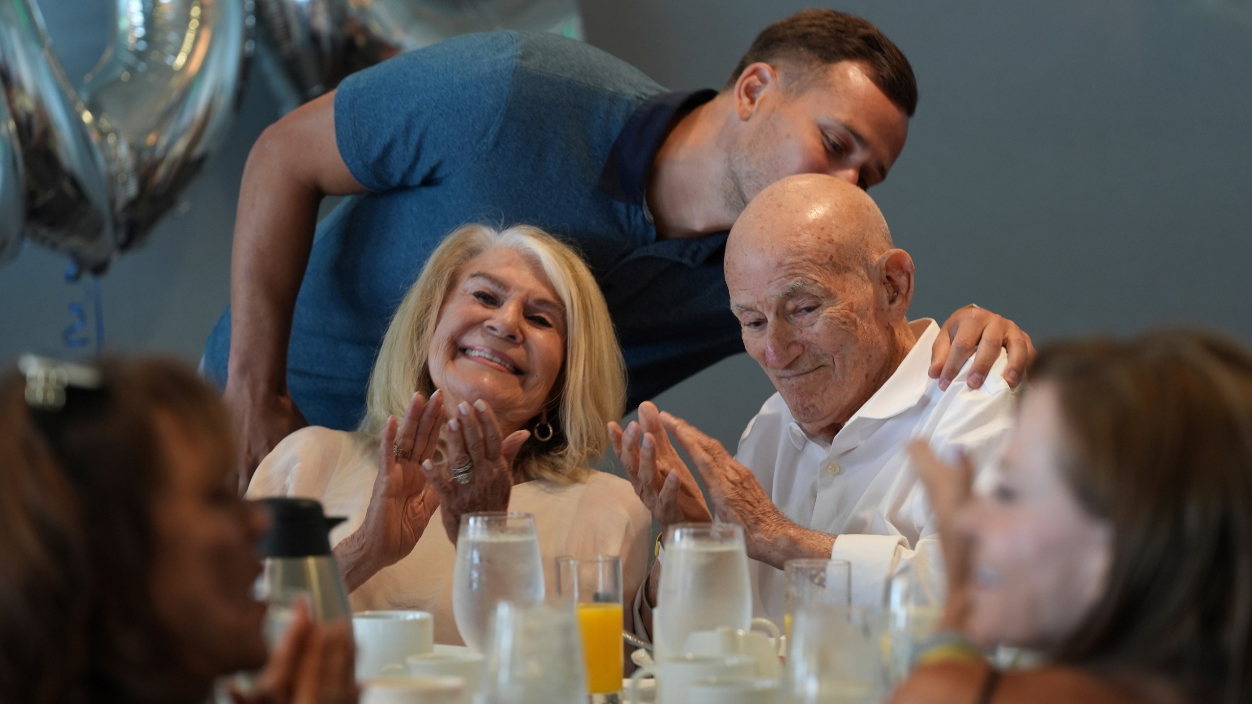 Tyler Terens kisses his grandfather Harold Terens, a World War II veteran who fought in D-Day. after speaking at his 102 birthday party, Saturday, July 26, 2025, in Delray Beach, Fla. (AP Photo/Marta Lavandier)