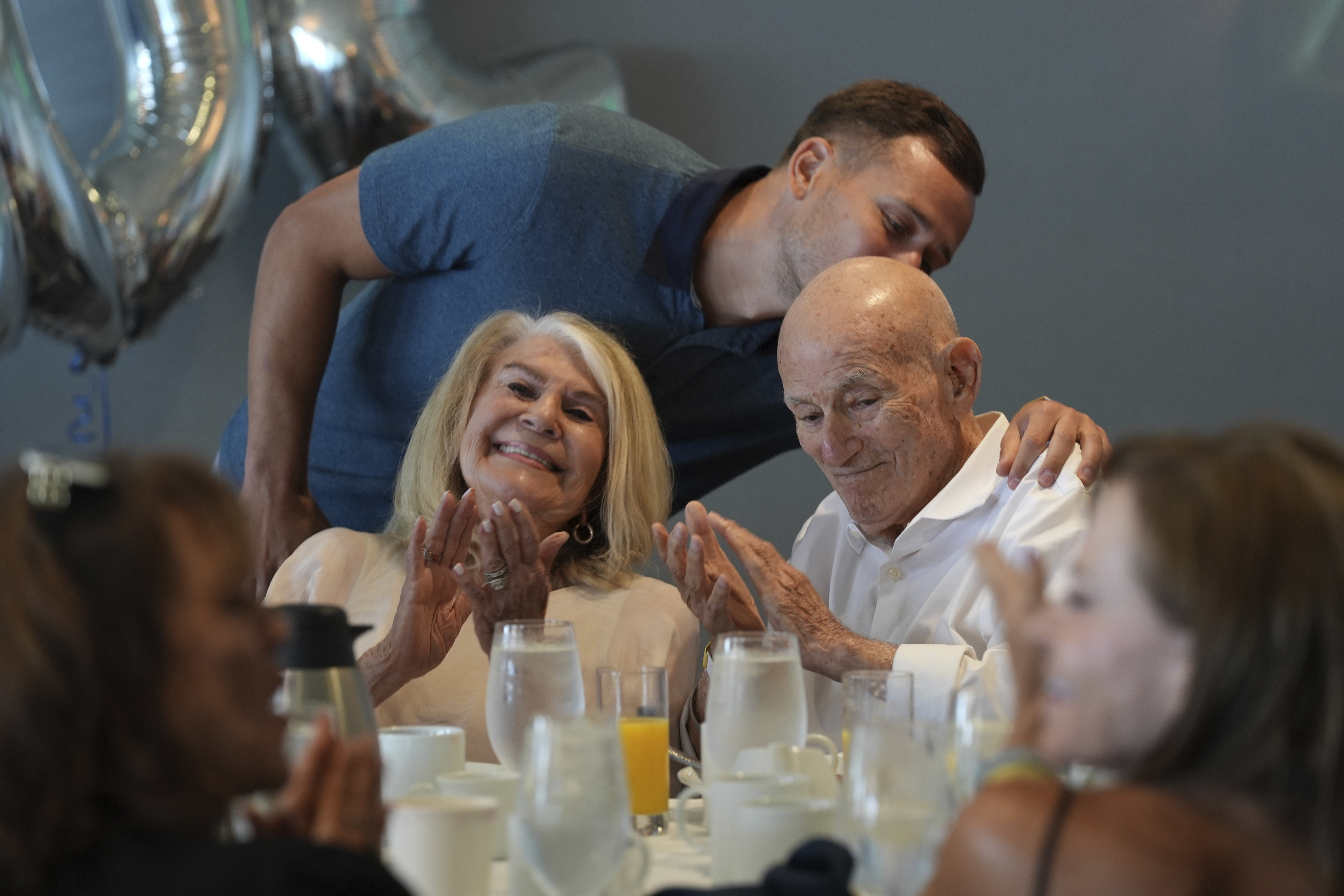 Tyler Terens kisses his grandfather Harold Terens, a World War II veteran who fought in D-Day. after speaking at his 102 birthday party, Saturday, July 26, 2025, in Delray Beach, Fla. (AP Photo/Marta Lavandier)