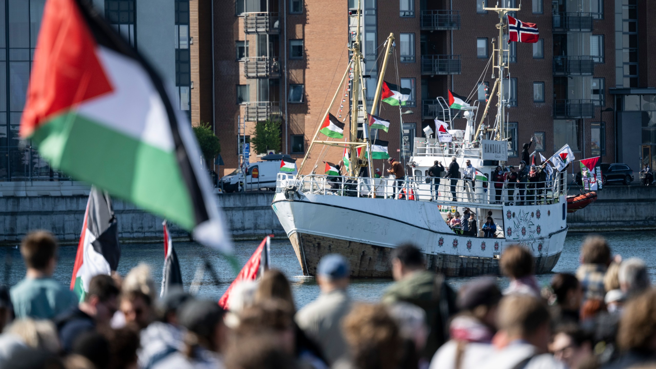FILE - Demonstrators carrying Palestinian flags look on as the Ship to Gaza boat 'Handala' arrives at the port of Malmö, Sweden, Wednesday, May 8, 2024.(Johan Nilsson/TT News Agency via AP, File)