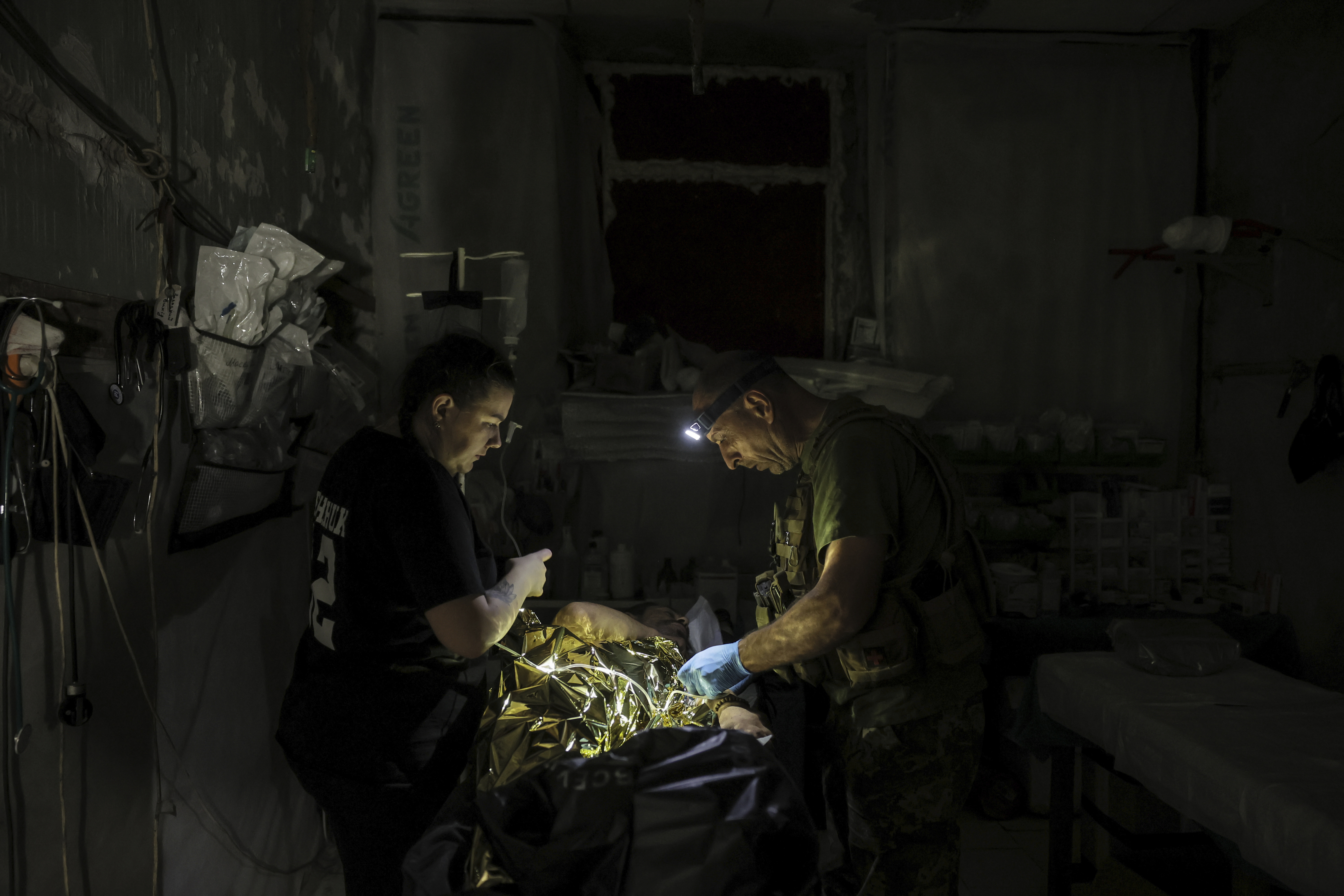In this photo provided by Ukraine's 24th Mechanized Brigade press service, military medics give first aid to a wounded Ukrainian soldier at a medical stabilisation point in Donetsk region, Ukraine, Friday, July 25, 2025, (Oleg Petrasiuk/Ukraine's 24th Mechanized Brigade via AP)