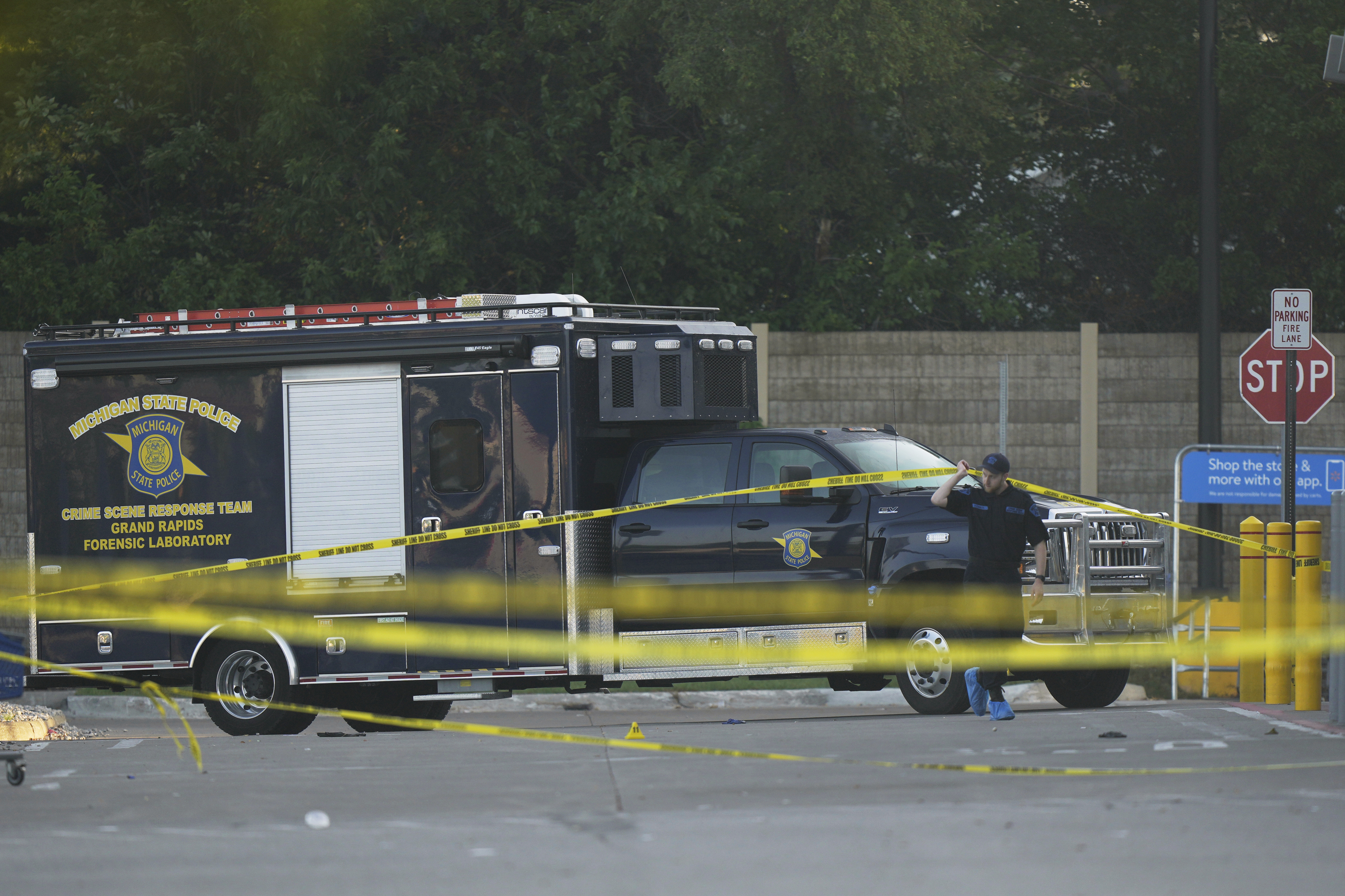 Law enforcement officers are seen stationed outside a Walmart where several people were stabbed in a violent attack Saturday, July 26, 2025, in Traverse City, Mich. (AP Photo/Ryan Sun)