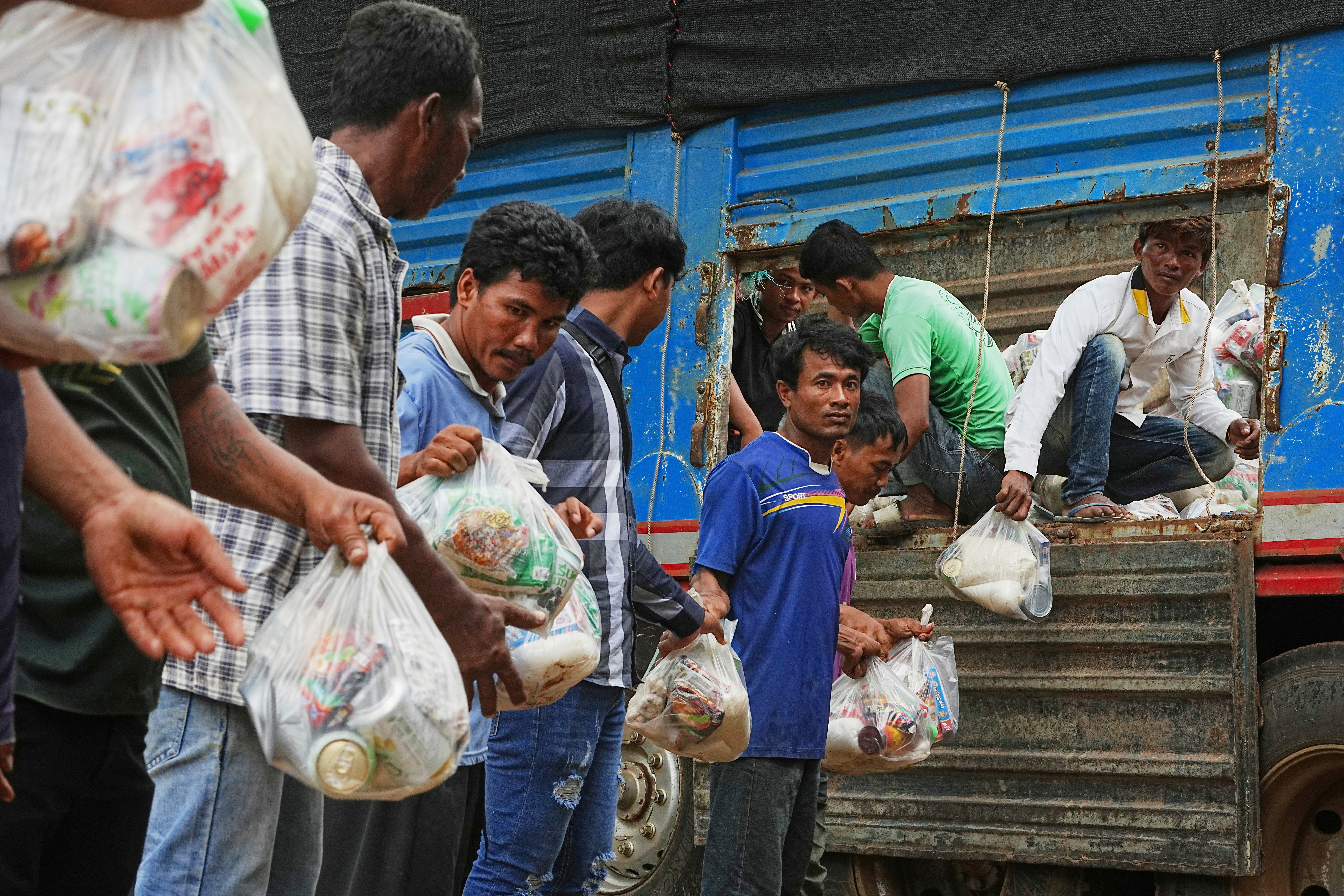 Local villagers help unloading supplies donated by a charity for refugees from a truck, as they take refuge in Wat Phnom Kamboar, Oddar Meanchey province, Cambodia, Sunday, July 27, 2025, amid the fighting between Thailand and Cambodia. (AP Photo/Heng Sinith)