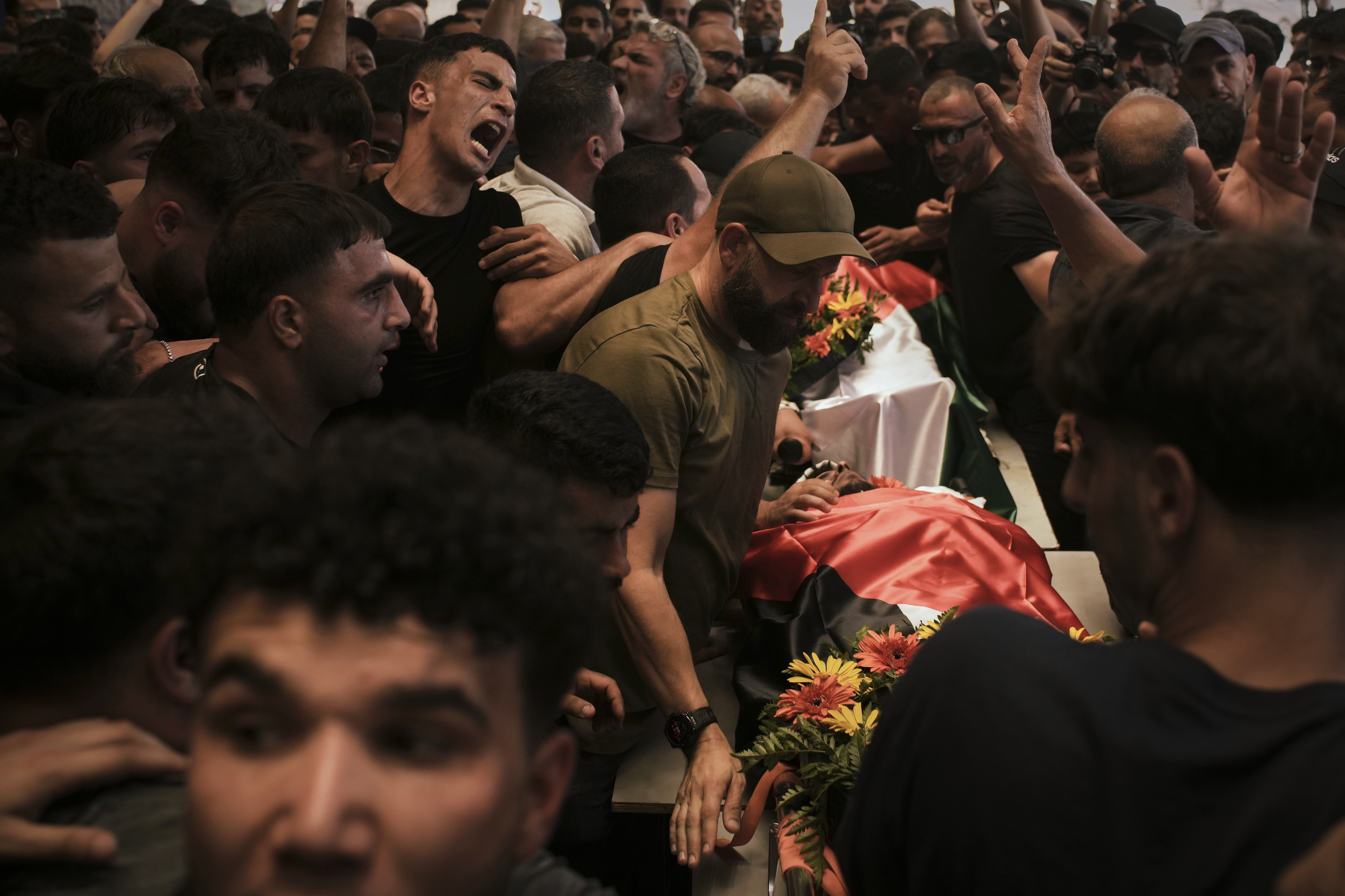 FILE - Mourners carry the bodies of Palestinian-American Sayfollah Musallet and Mohammed al-Shalabi during their funeral in the West Bank village of Al-Mazraa a-Sharqiya on Sunday, July 13, 2025. (AP Photo/Leo Correa, File)