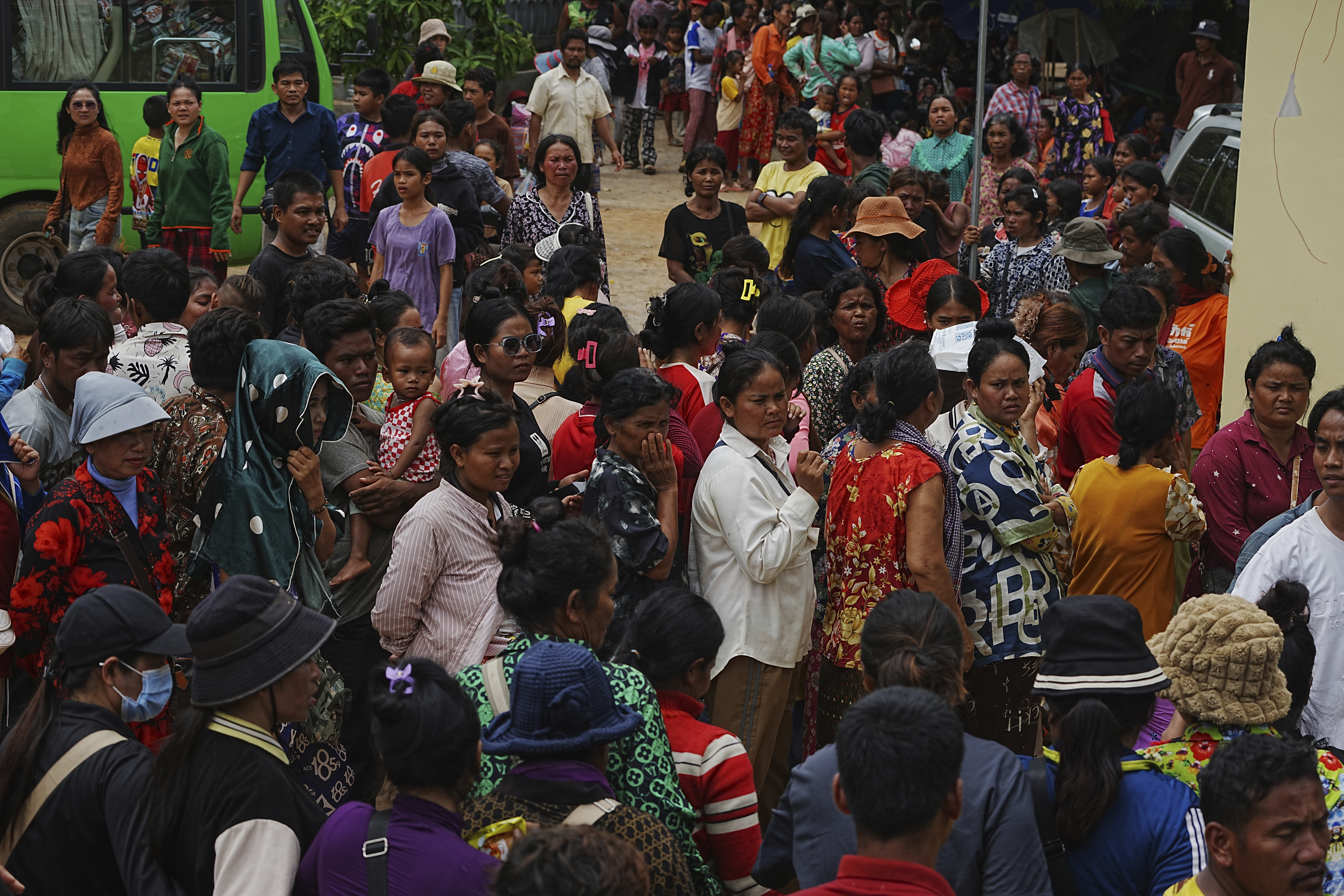 Local villagers wait to receive supplies donated by a charity, in Wat Phnom Kamboar, Oddar Meanchey province, Cambodia, Sunday, July 27, 2025, amid the fighting between Thailand and Cambodia. (AP Photo/Heng Sinith)