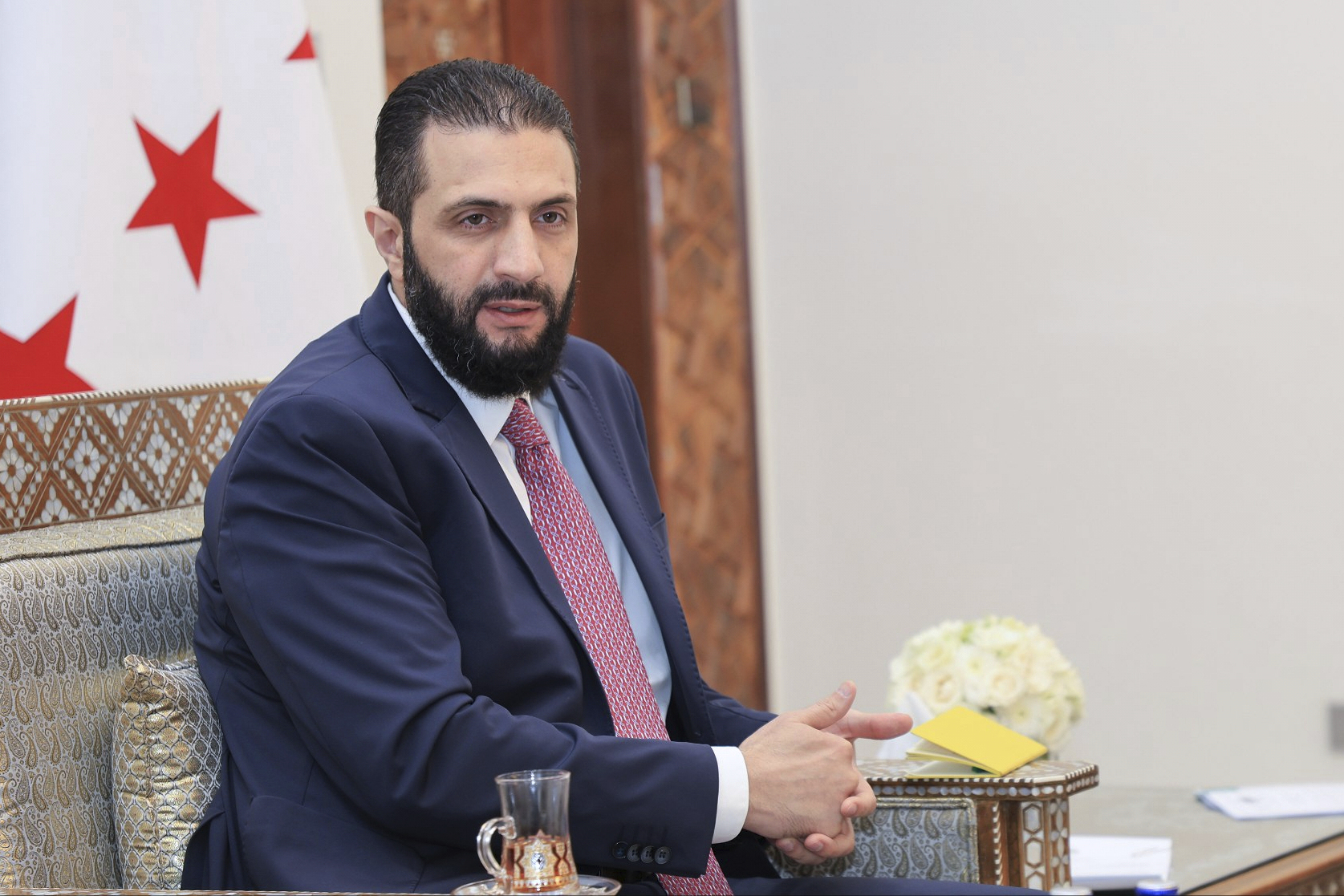 In this photo released by the Syrian official news agency SANA, Syria's interim President Ahmad al-Sharaa receives the final version of the provisional electoral system for the People's Assembly, in Damascus, Syria, Sunday, July 27, 2025. (SANA via AP)