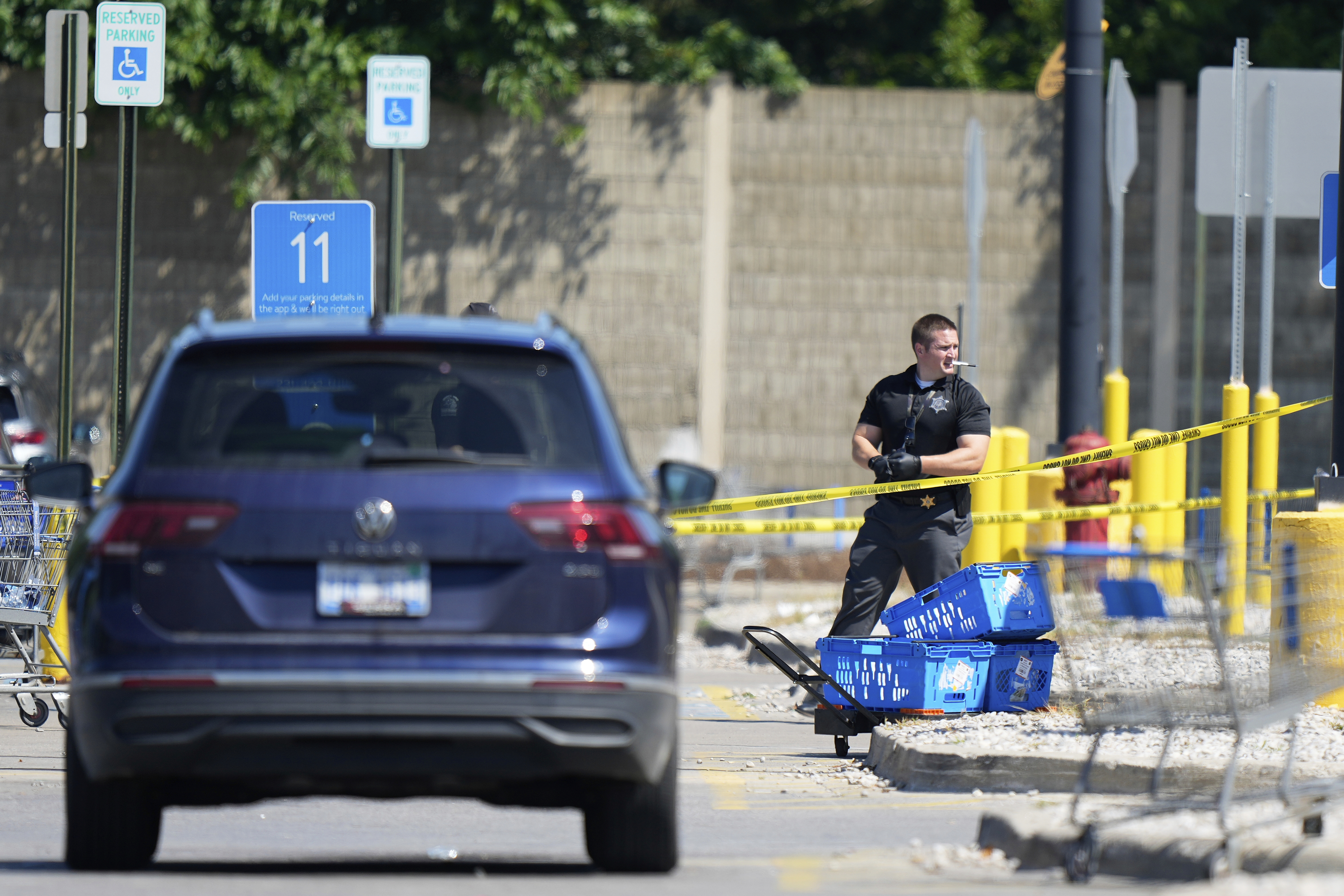 Law enforcement officers investigate outside of a Walmart, Sunday, July 27, 2025, where a multiple stabbing took place on Saturday, in Traverse City, Mich. (AP Photo/Ryan Sun)