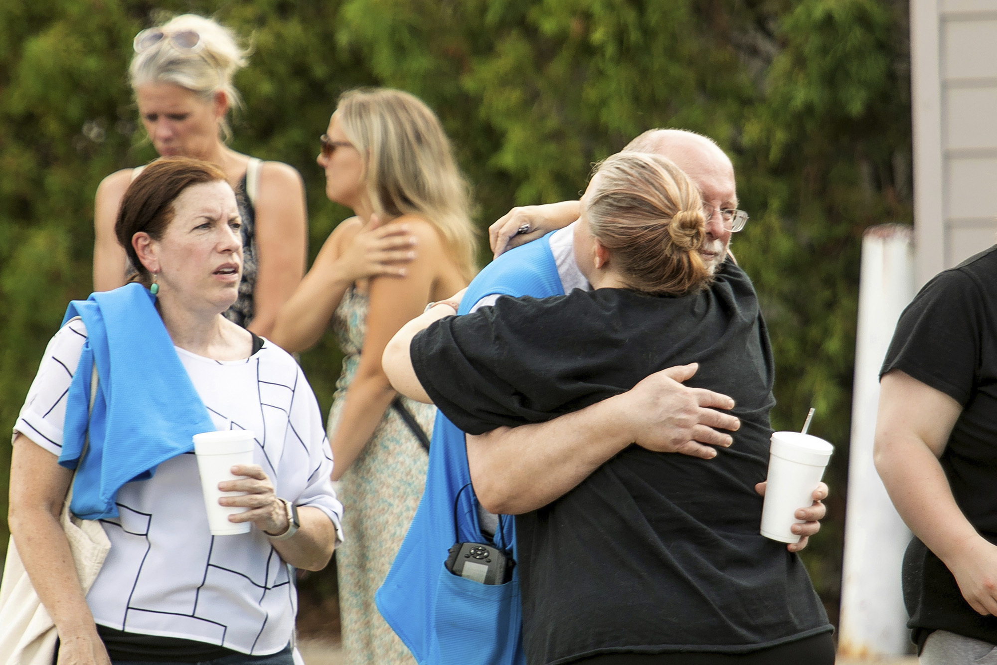 Walmart employees and customers wait outside while law enforcement investigates the scene after a stabbing incident in Traverse City, Mich., Saturday July 26, 2025. (Jan-Michael Stump/Traverse City Record-Eagle via AP)