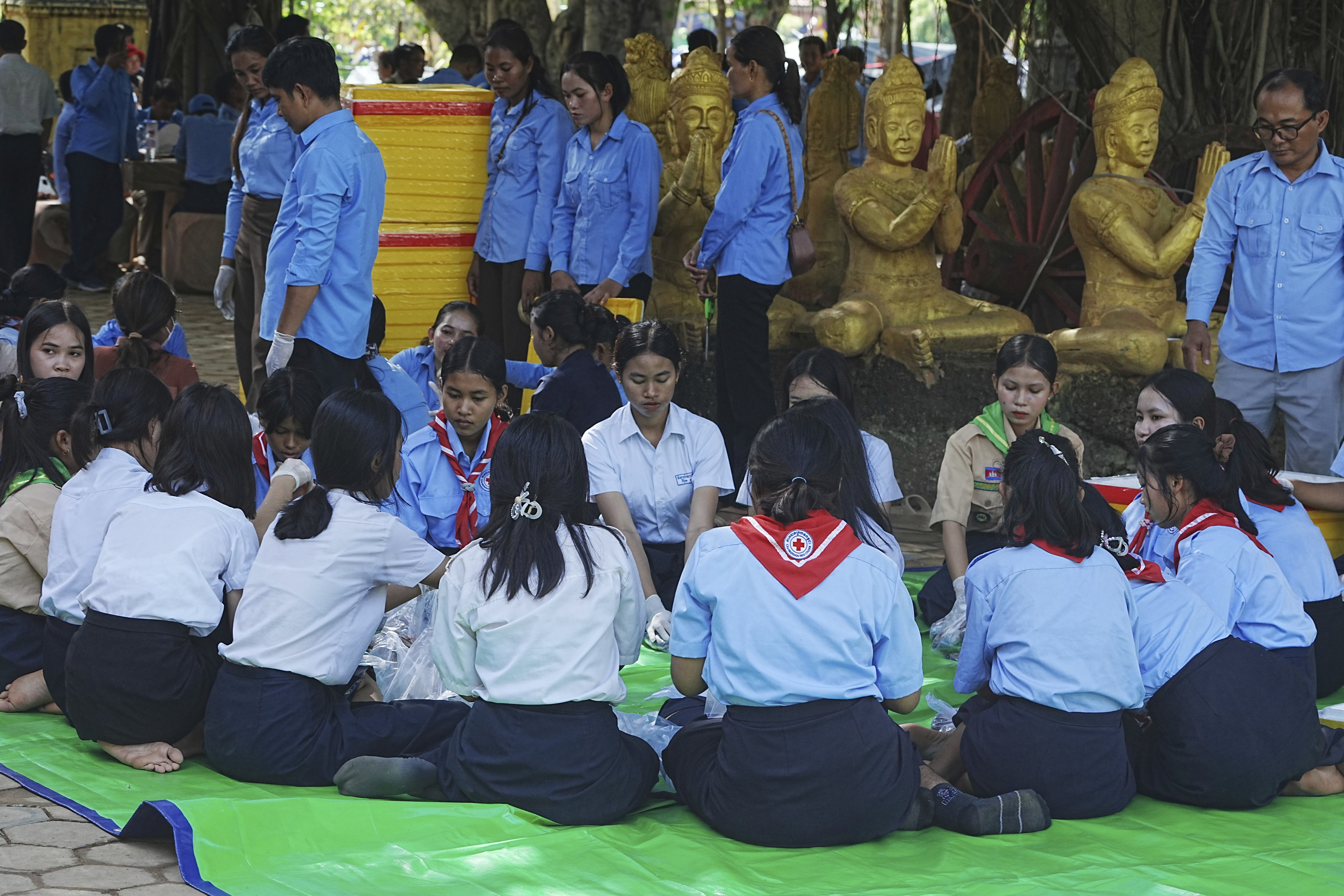 Local students wrap food to give to villagers while they take refuge in Buddhist pagoda in Srey Snam district, Siem Reap province, Cambodia, Sunday, July 28, 2025, amid the fighting between Thailand and Cambodia. (AP Photo/Heng Sinith)