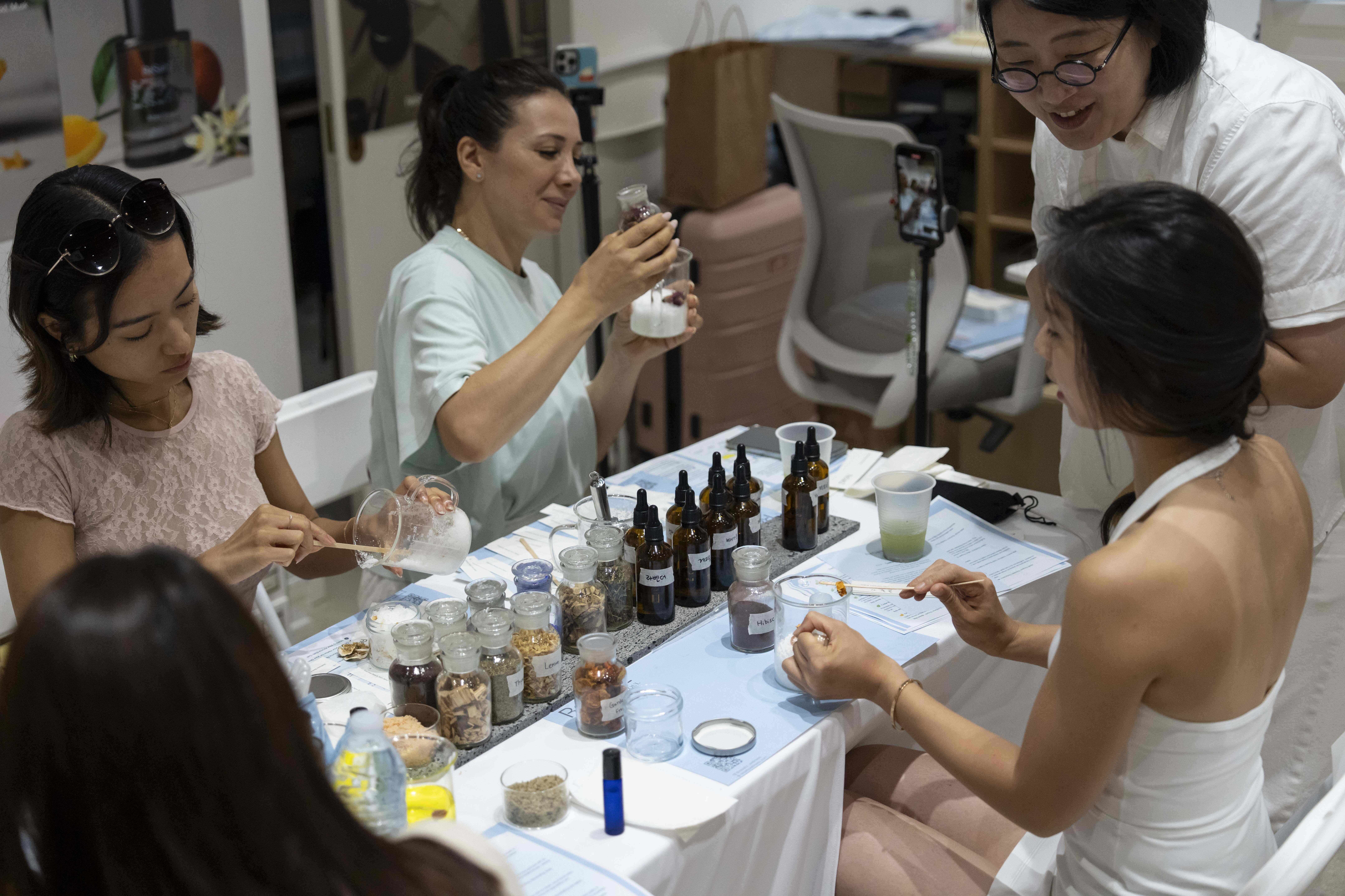 Customers and influencers try on new Korean perfume during a workshop at Senti Senti in New York on Friday, July 25, 2025. (AP Photo/Yuki Iwamura)