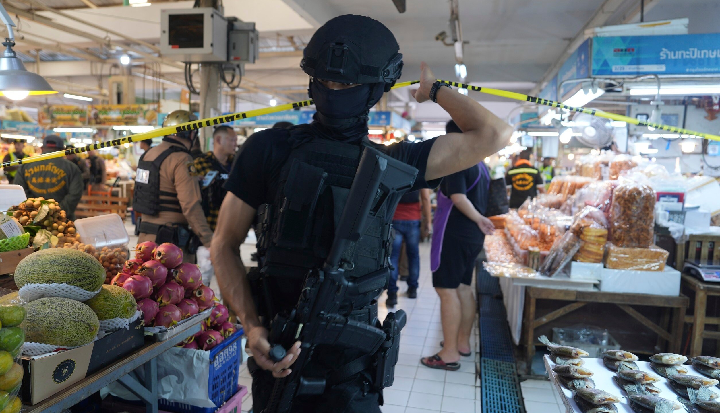 A policeman of a special operations unit at a crime scene at a market in Bangkok, Thailand, Monday, July 28, 2025 where police says six people are dead after a shooting incident. (AP Photo/Nava Sangthong)