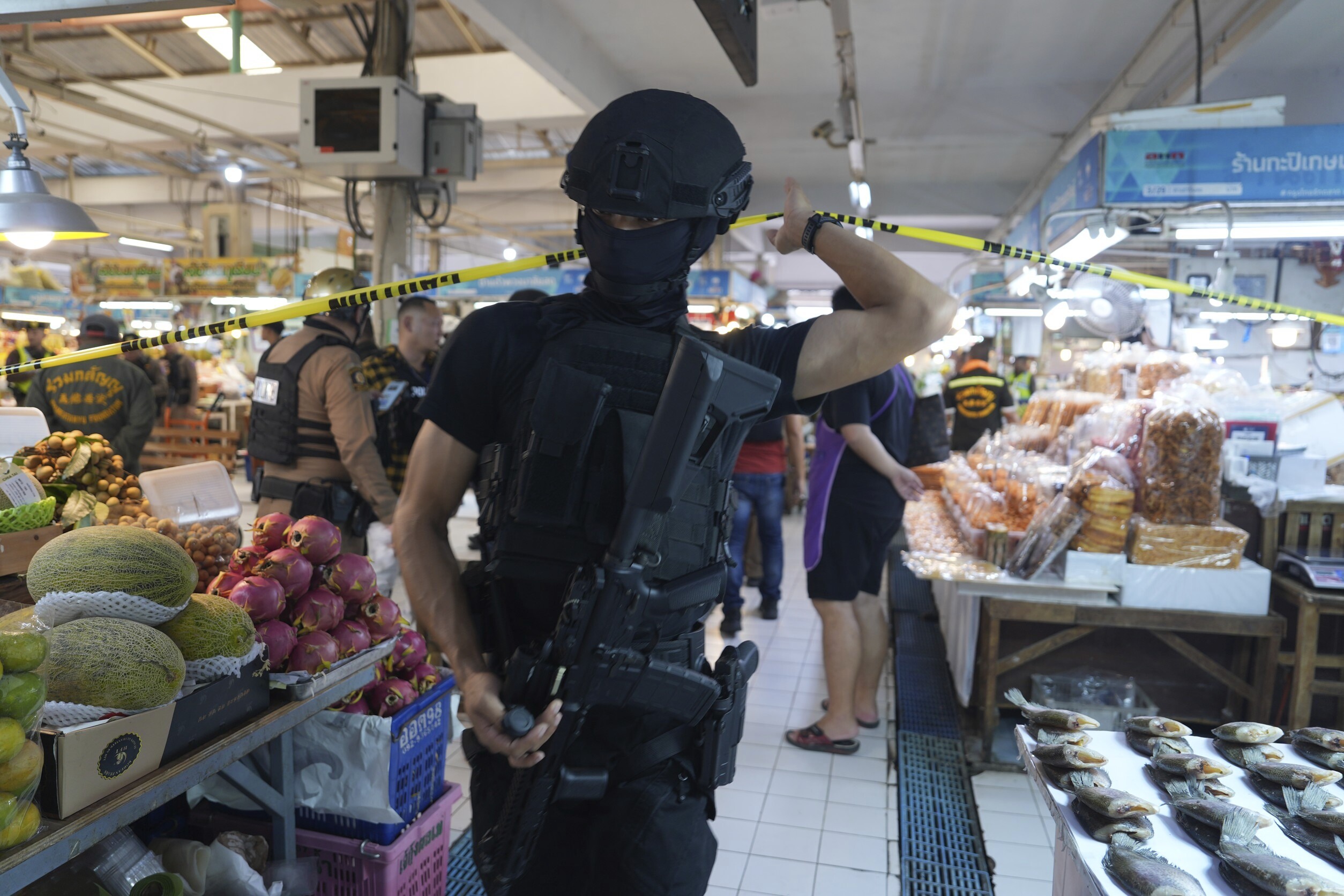 A policeman of a special operations unit at a crime scene at a market in Bangkok, Thailand, Monday, July 28, 2025 where police says six people are dead after a shooting incident. (AP Photo/Nava Sangthong)