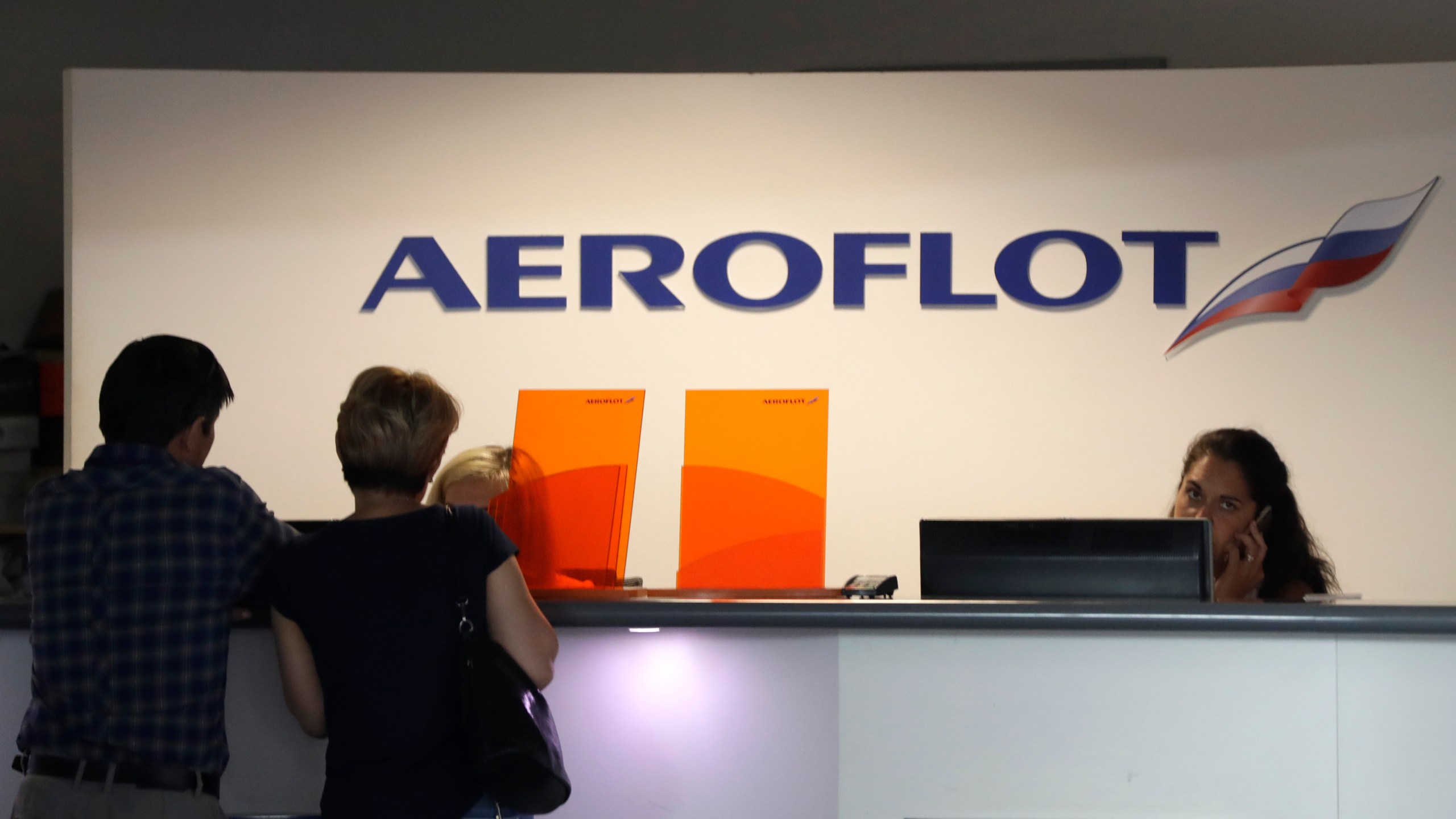 FILE - Customers stand by a counter of Russian airline Aeroflot at the airport in Prague, Czech Republic, Tuesday, July 2, 2019. (AP Photo/Petr David Josek, file)