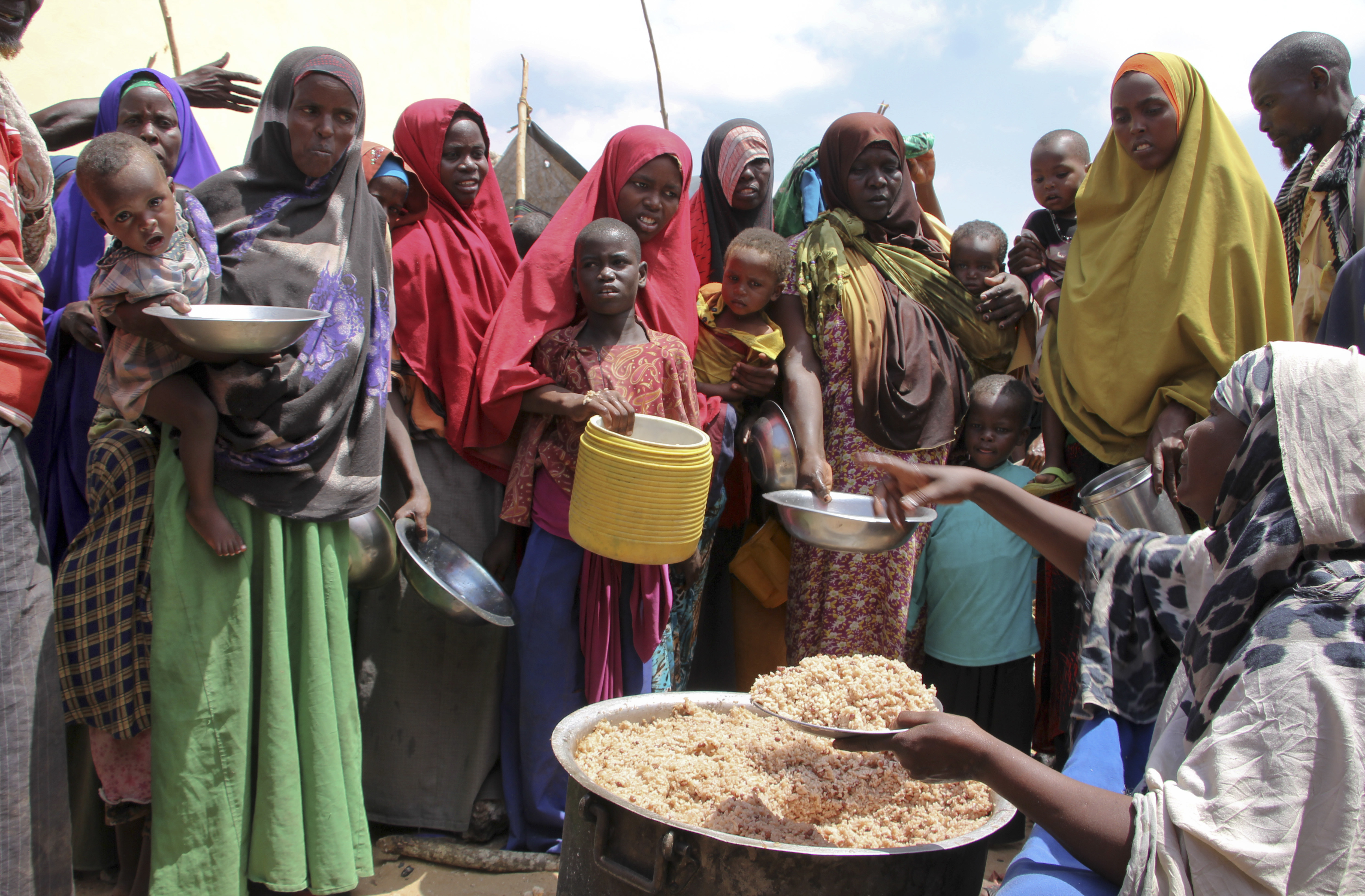 FILE - Newly arrived Somalis, displaced by a drought, receive food distributions at makeshift camps in the Tabelaha area on the outskirts of Mogadishu, Somalia on March 30, 2017. (AP Photo/Farah Abdi Warsameh, File)