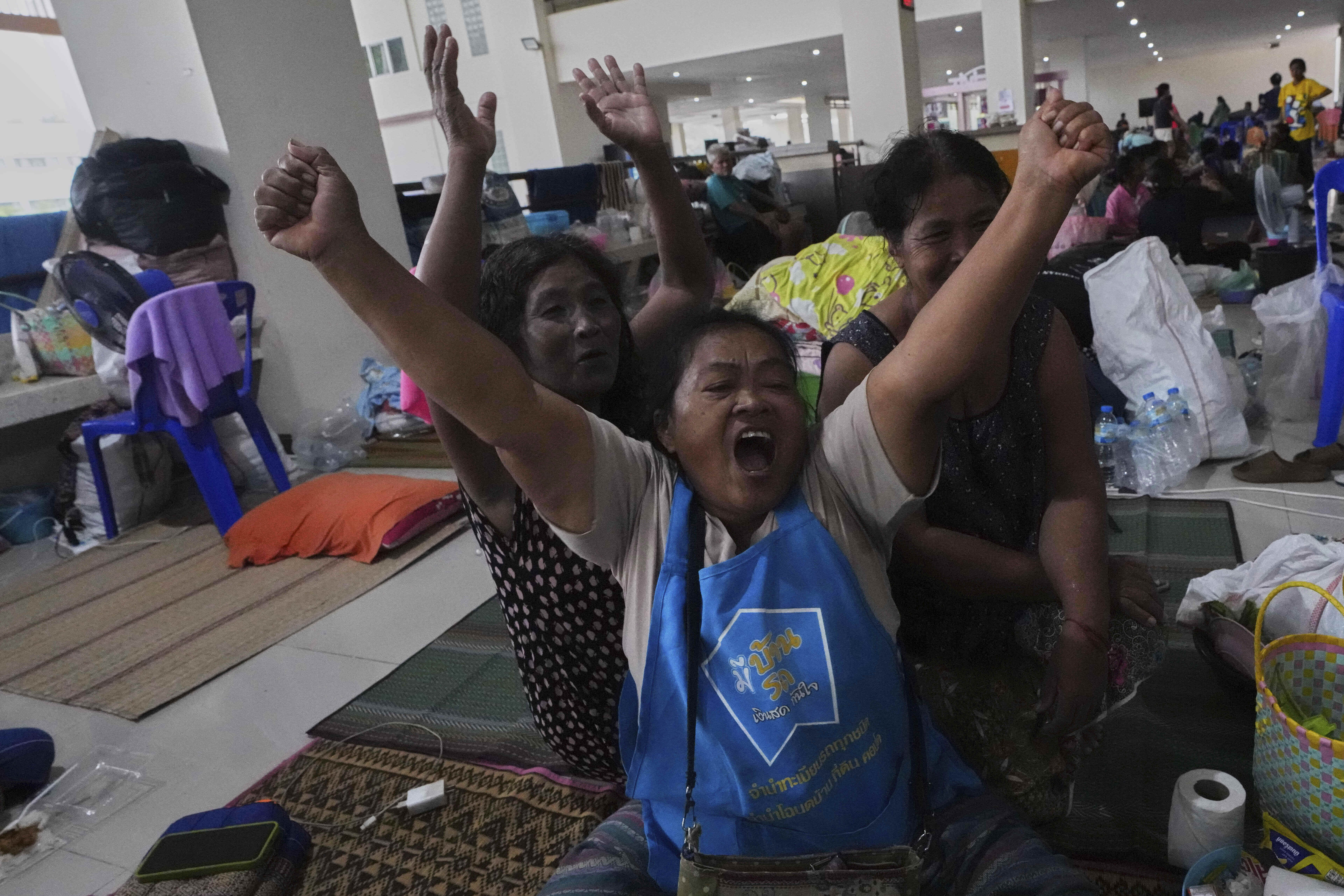 Thai residents who fled homes following the clashes between Thai and Cambodian soldiers, celebrate at an evacuation center in Surin province, Thailand, Monday, July 28, 2025 after hearing Immediate and unconditional cease fire with effect from 24 hours local time, midnight on 28 July 2025. (AP Photo/Sakchai Lalit)