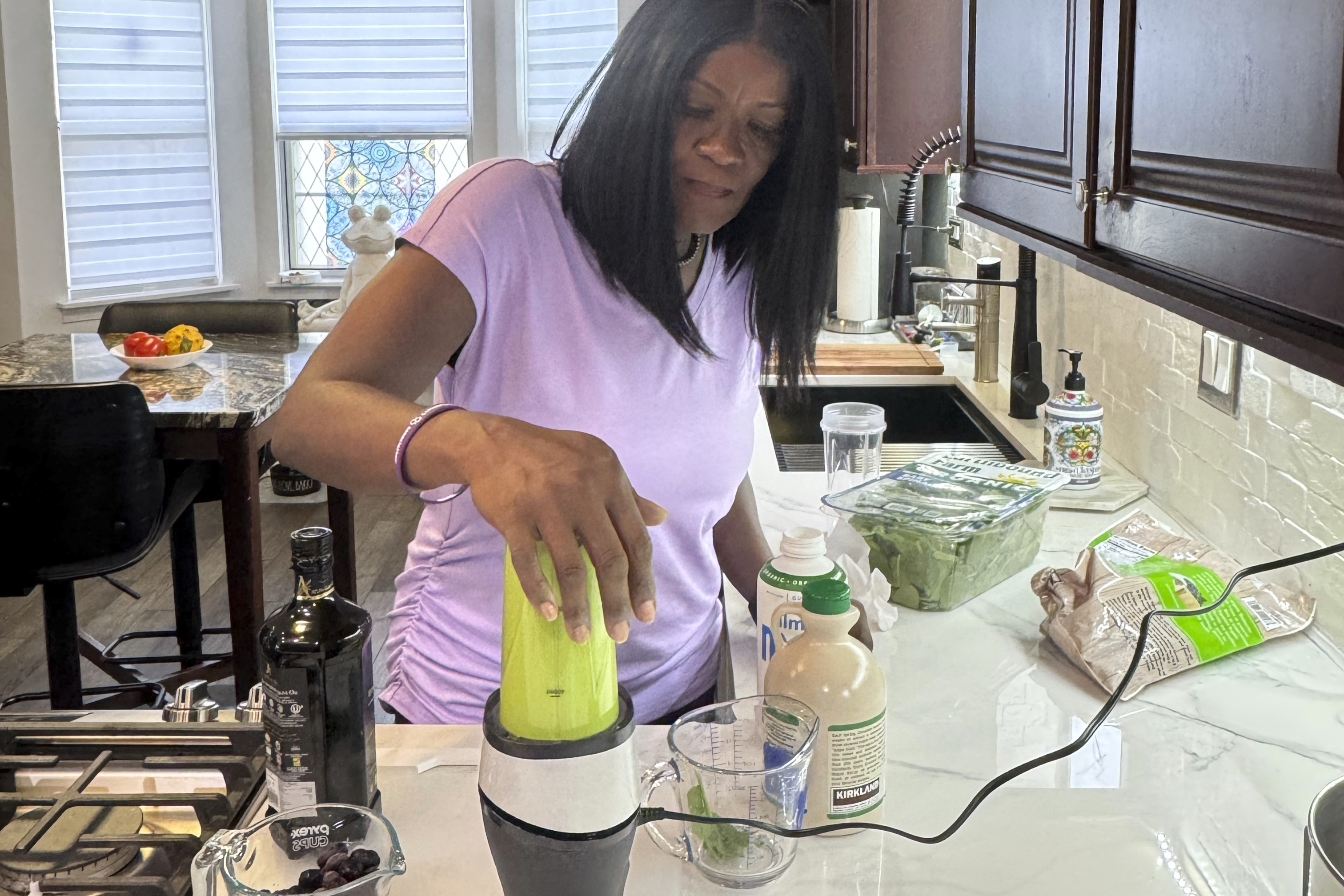 In this photo provided by Phyllis Jones, she prepares a smoothie with spinach, frozen blueberries, almond milk with pumpkin spice and date sugar at home in Aurora, Ill., on Friday, July 25, 2025. (Courtesy Phyllis Jones via AP)