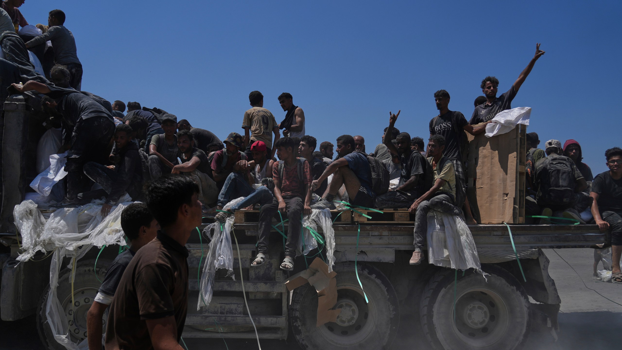 Palestinians hold onto an aid truck returning to Gaza City from the northern Gaza Strip, Sunday, July 27, 2025. (AP Photo/Abdel Kareem Hana)