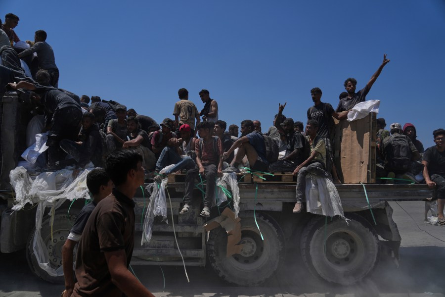 Palestinians hold onto an aid truck returning to Gaza City from the northern Gaza Strip, Sunday, July 27, 2025. (AP Photo/Abdel Kareem Hana)