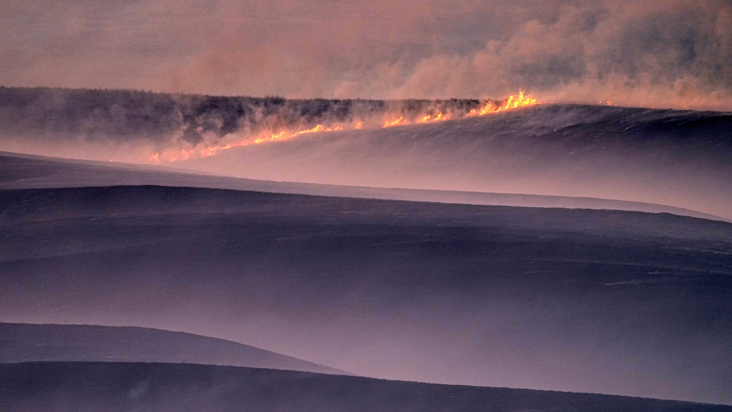 FILE- Wind fueled fires burn in a pasture which was part of a fire that burned and stretched across Ellis, Russell, Osborne and Rooks counties, Dec. 16, 2021, near Natoma, Kan. (AP Photo/Charlie Riedel, file)