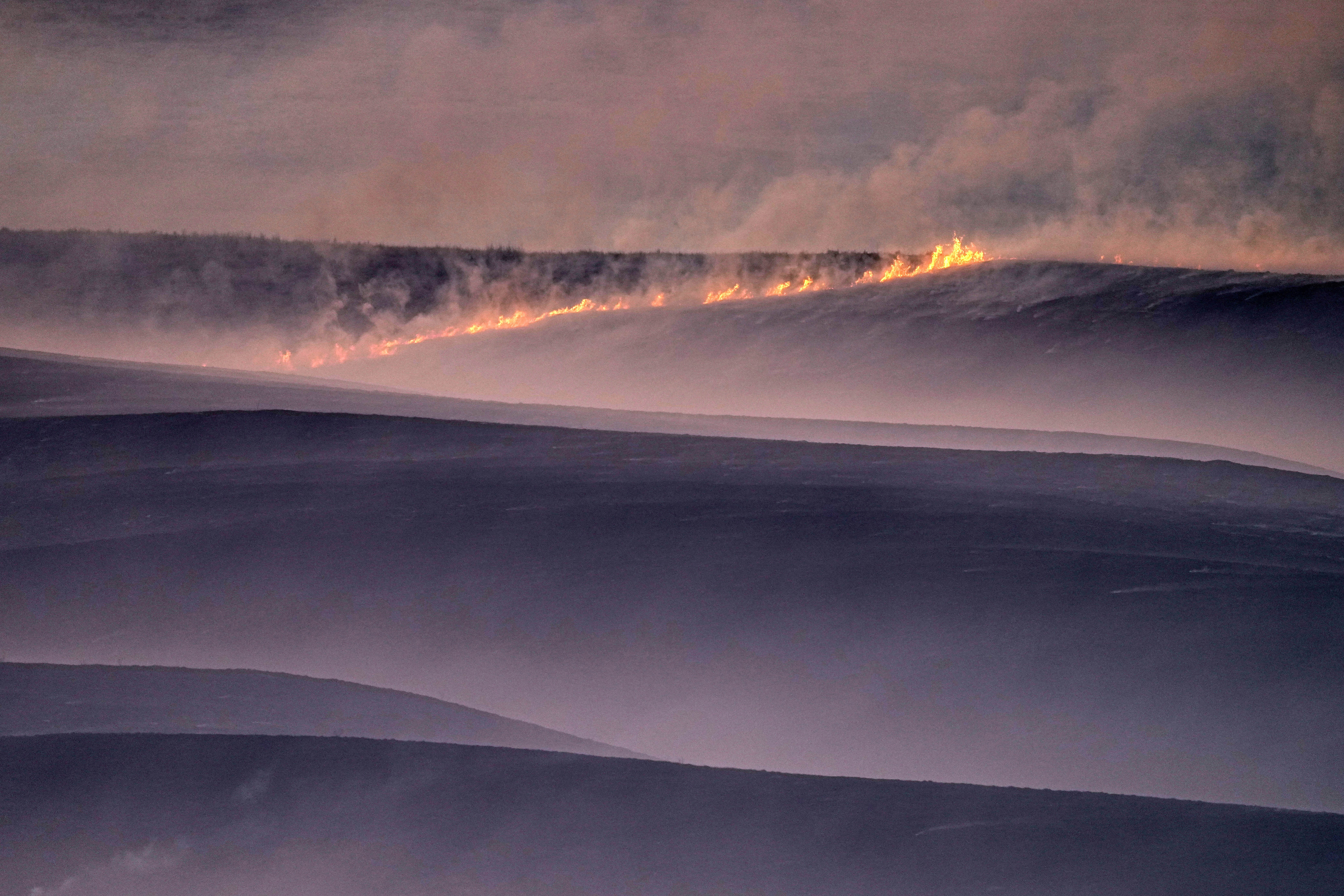 FILE- Wind fueled fires burn in a pasture which was part of a fire that burned and stretched across Ellis, Russell, Osborne and Rooks counties, Dec. 16, 2021, near Natoma, Kan. (AP Photo/Charlie Riedel, file)