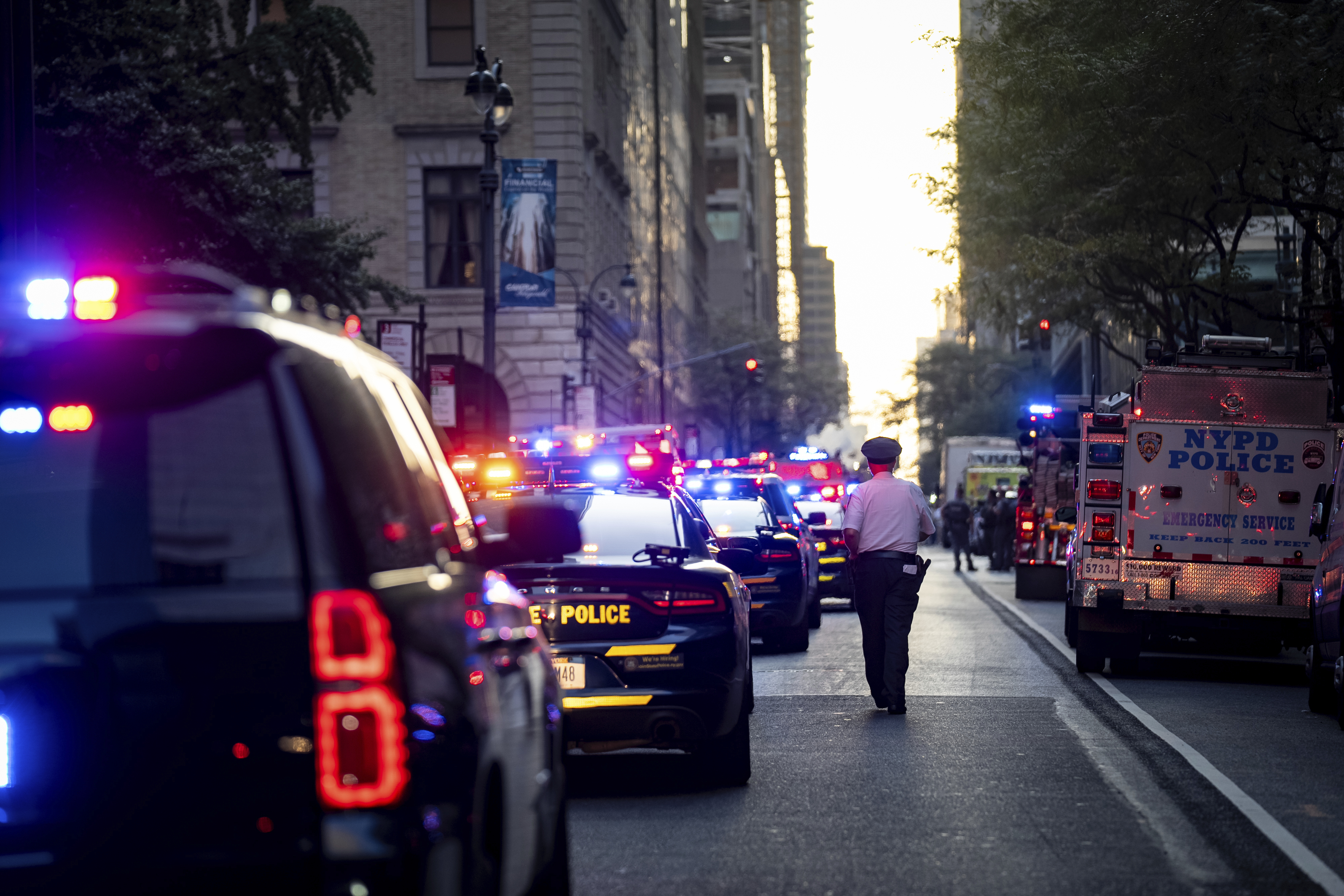 A New York police officer stands watch on 52nd Street outside a Manhattan office building where at least two people were shot, including a police officer, Monday, July 28, 2025, in New York. (AP Photo/Angelina Katsanis)