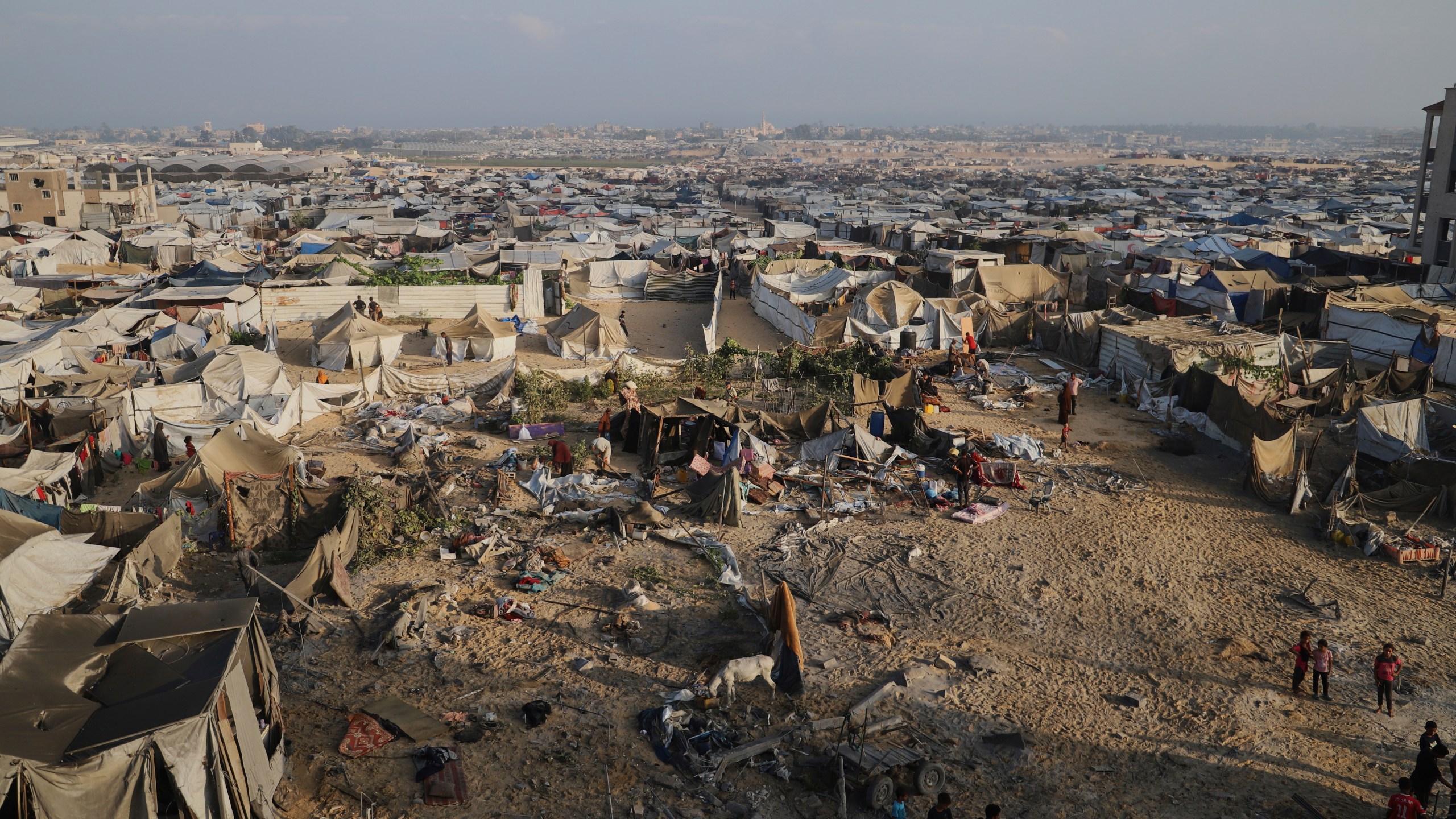 Palestinians inspect the site struck by an Israeli bombardment in Muwasi, Khan Younis, Gaza Strip, Monday, July 28, 2025. (AP Photo/Mariam Dagga)