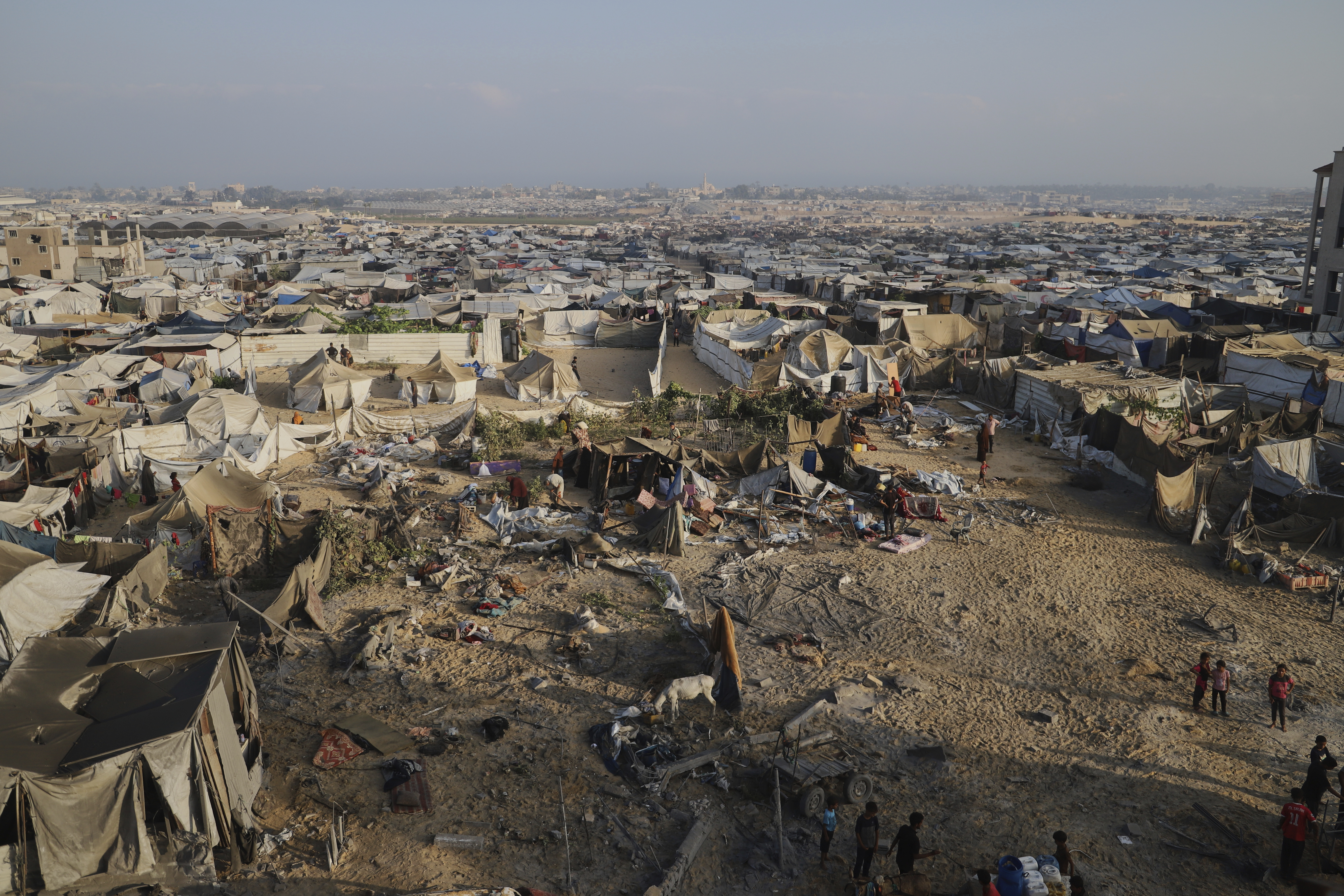 Palestinians inspect the site struck by an Israeli bombardment in Muwasi, Khan Younis, Gaza Strip, Monday, July 28, 2025. (AP Photo/Mariam Dagga)