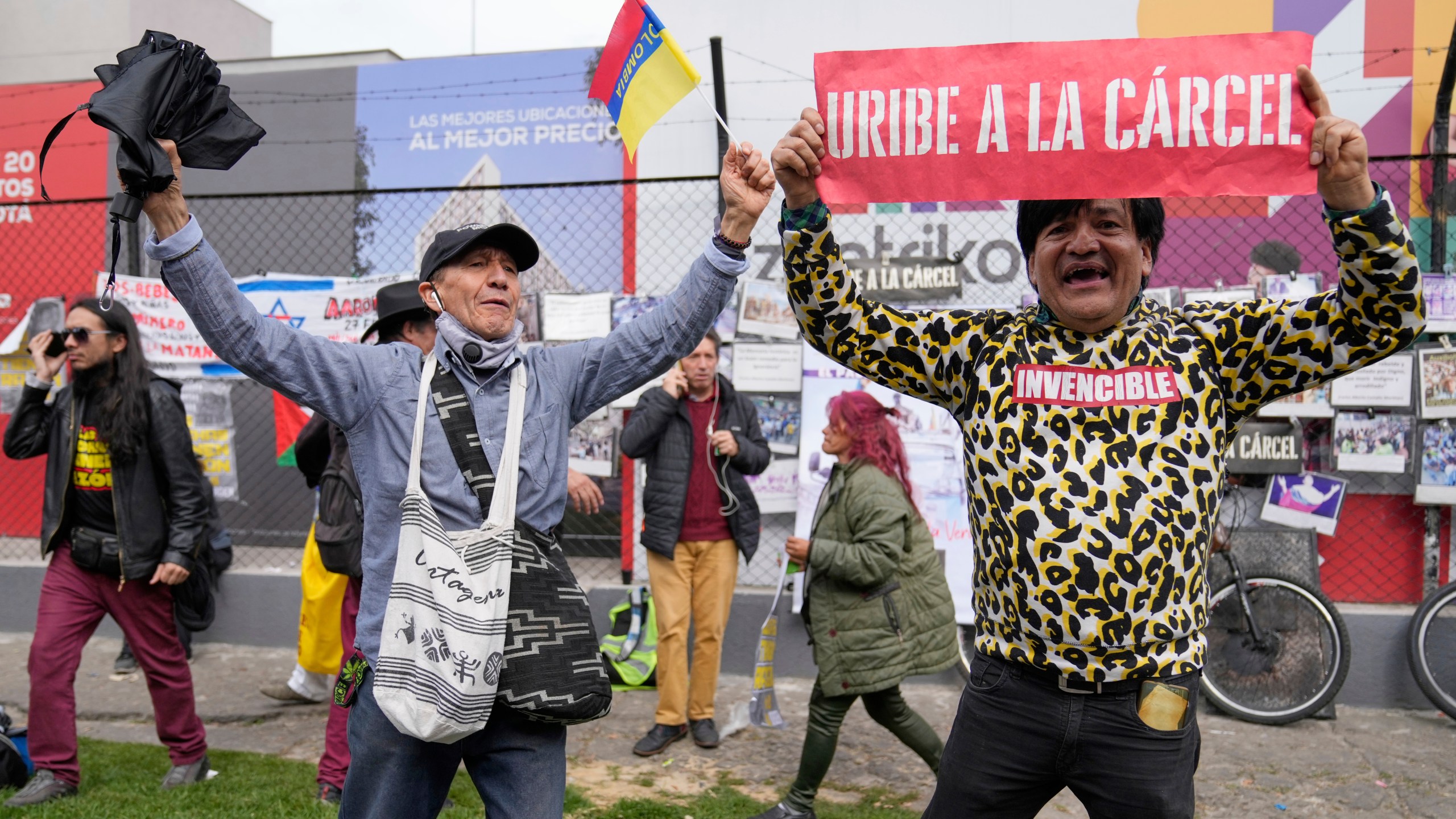 An opponent of former President Alvaro Uribe displays a sign reading in Spanish "Uribe to jail" outside the court where a verdict is expected in his trial for witness tampering in Bogota, Colombia, Monday, July 28, 2025. (AP Photo/Fernando Vergara)
