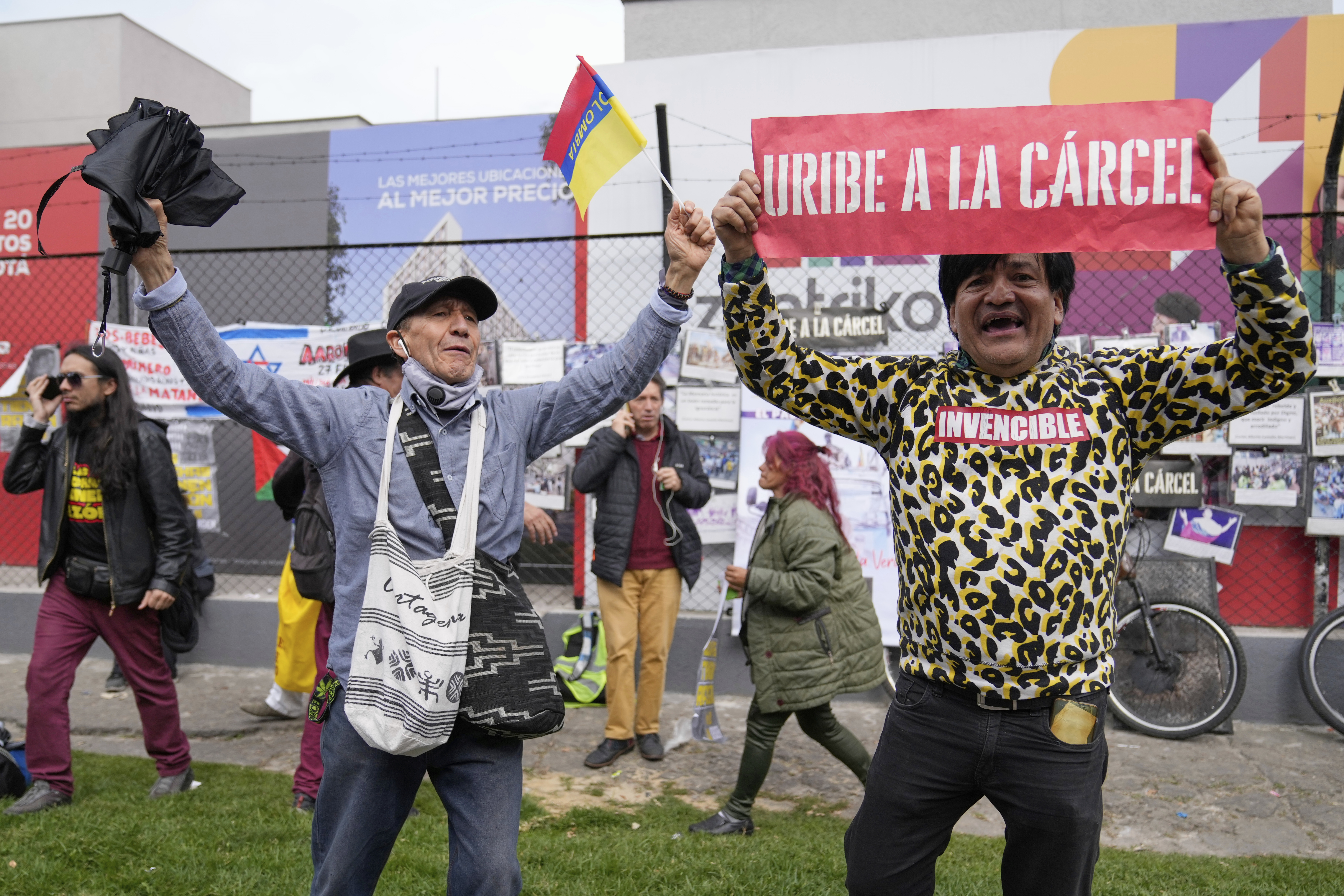 An opponent of former President Alvaro Uribe displays a sign reading in Spanish "Uribe to jail" outside the court where a verdict is expected in his trial for witness tampering in Bogota, Colombia, Monday, July 28, 2025. (AP Photo/Fernando Vergara)
