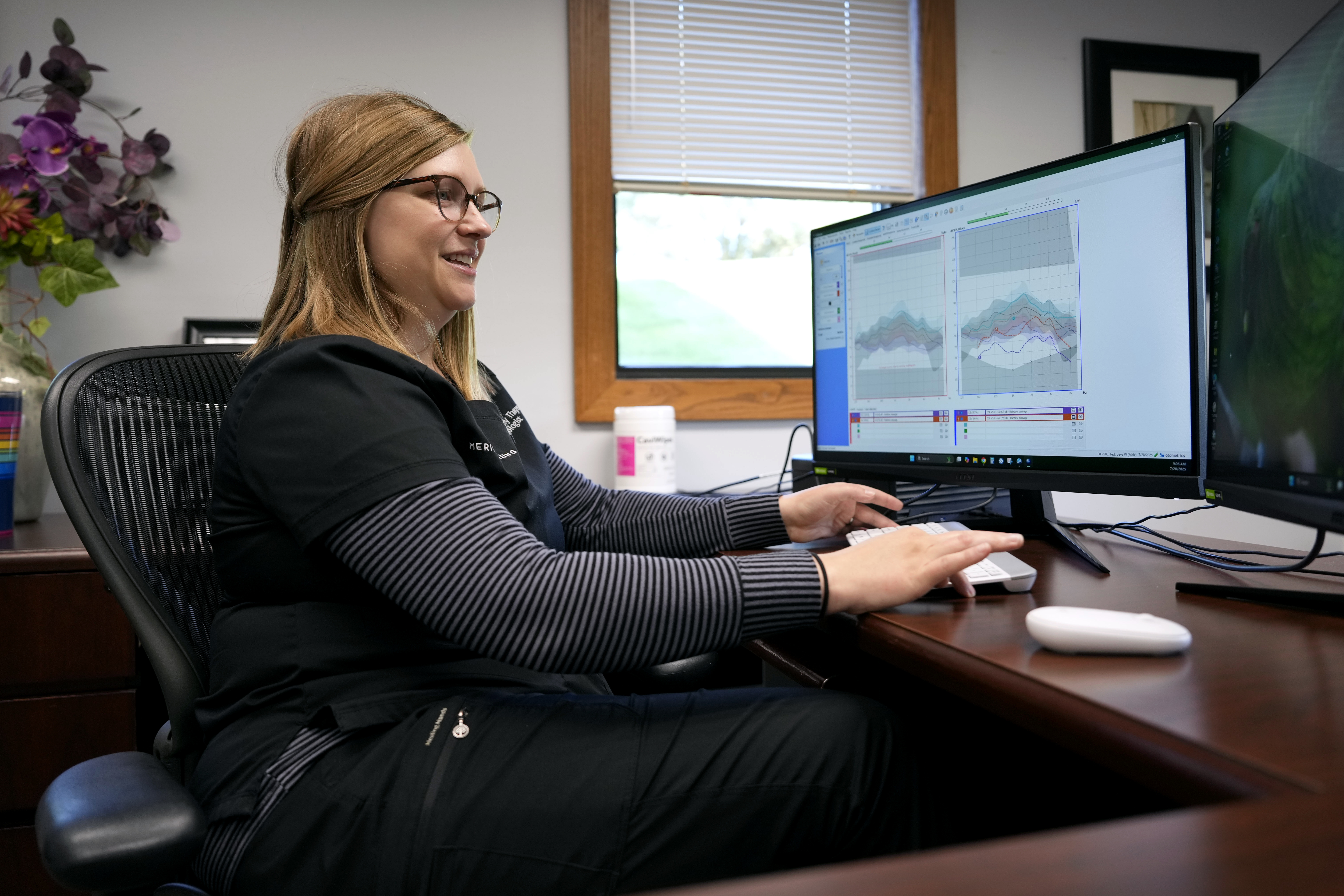 Audiologist Courtney Thayer sits at her desk in her office, Monday, July 28, 2025, in West Des Moines, Iowa. A new AP-NORC poll finds that most Americans say they have used artificial intelligence to search for information, according to a new poll that highlights the ubiquity of the technology. But it's younger adults who appear to be the generation leaning the most into AI, with many using it for brainstorms and work tasks. (AP Photo/Charlie Neibergall)