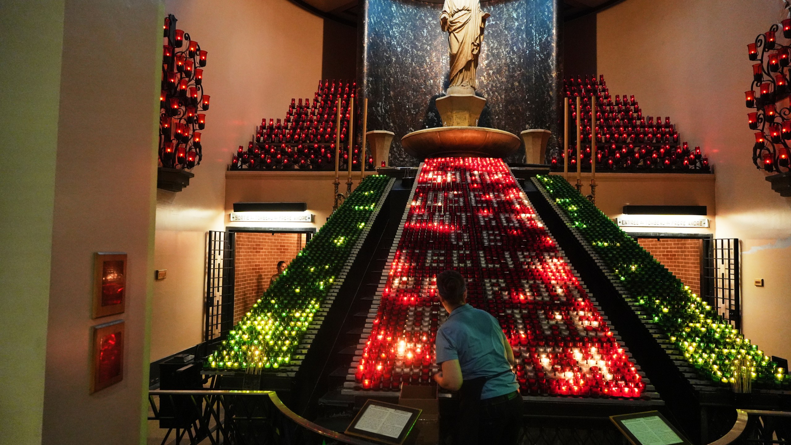 A worker arranges candles inside the Votive Chapel at the national shrine of Saint Joseph's Oratory of Mount Royal, in Montreal, Saturday, June 28, 2025. (AP Photo/Luis Andres Henao)