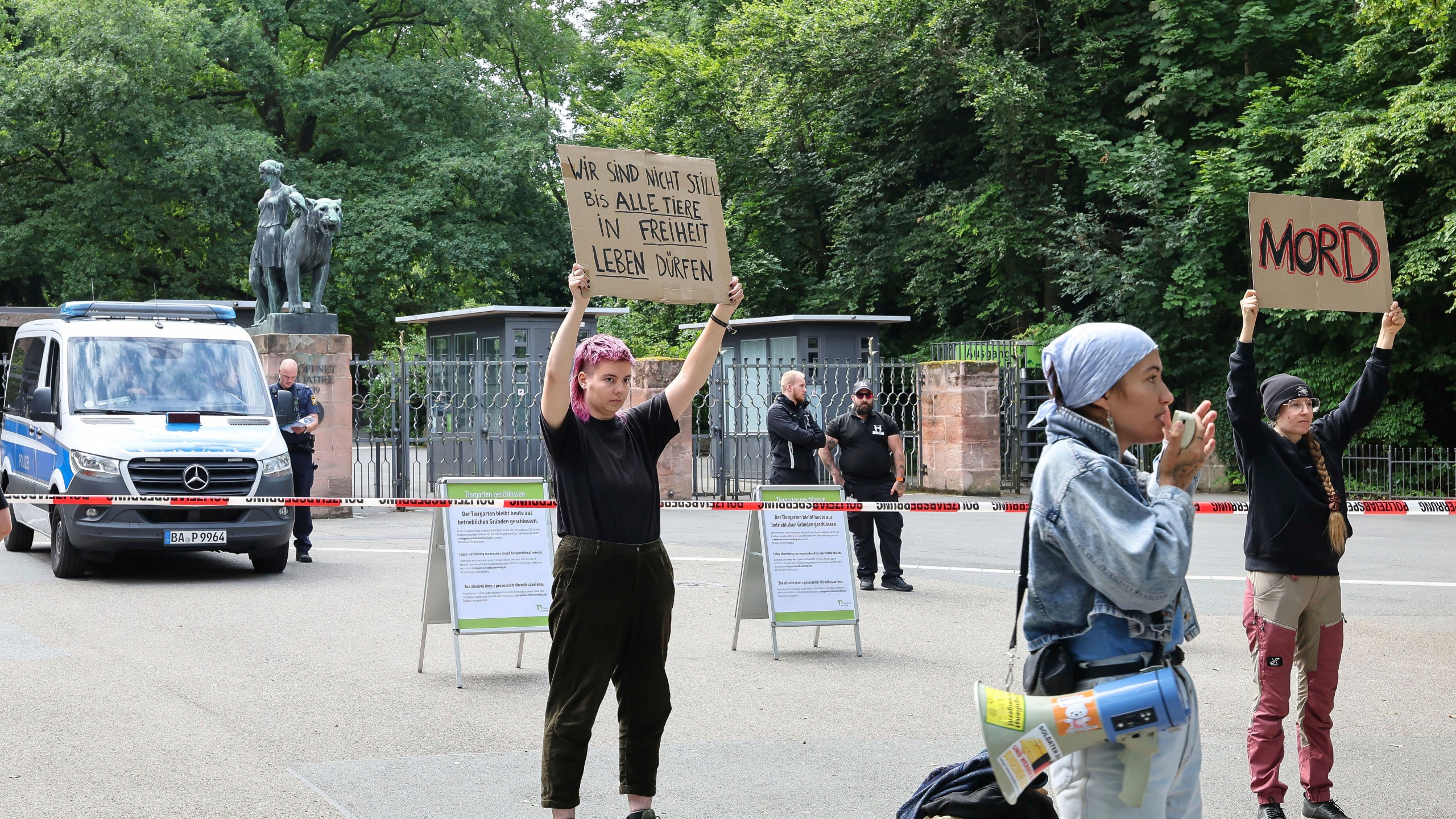 Demonstrators stand with protest signs in front of the Nuremberg Zoo in Nuremberg, Germany, Tuesday, July 29, 2025. Slogan reads 'we won't remain silence until all animals can live in freedom'. (Daniel Loeb/dpa via AP)