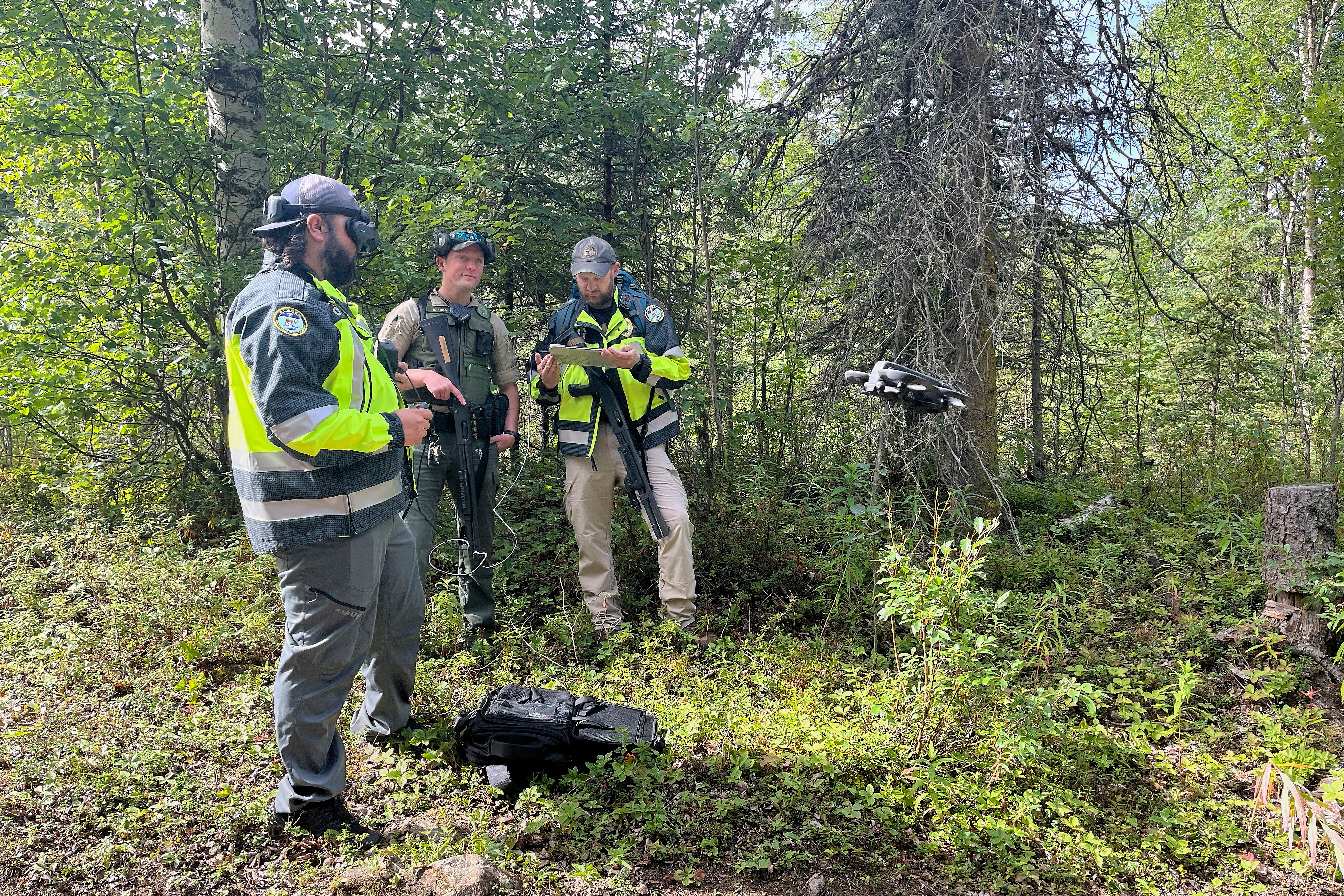 Wildlife officials prepare to fly a drone to look for a brown bear that had mauled a man on Saturday, July 26, 2025, near Eagle River, Alaska. (Timothy Burnett, Chugach State Park via AP)