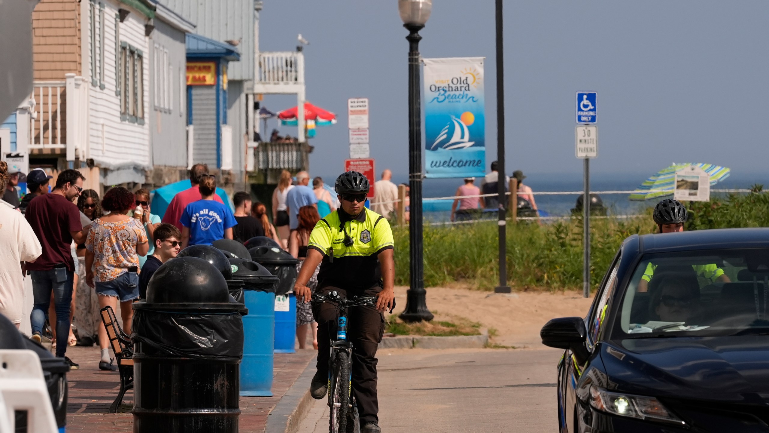 A Community Service Officer from the Old Orchard Beach Police Dept. patrols on a bicycle, Tuesday, July 29, 2025, in Old Orchard Beach, Maine. (AP Photo/Robert F. Bukaty)