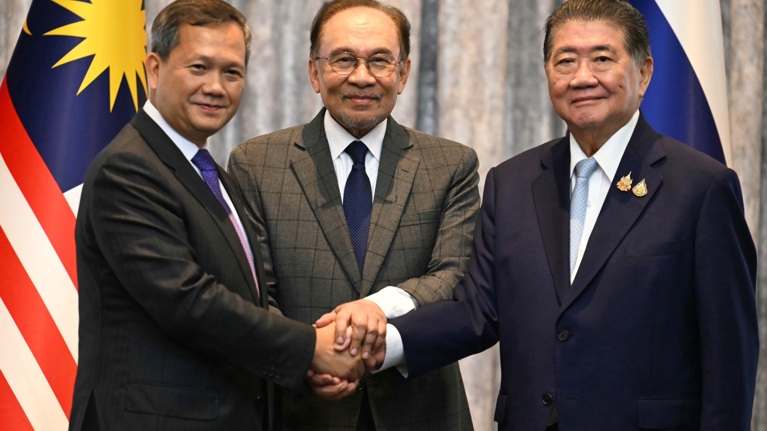 Malaysia's Prime Minister Anwar Ibrahim, center, Cambodia's Prime Minister Hun Manet left and Thailand's acting Prime Minister Phumtham Wechayachai pose for photos after talks on a possible ceasefire between Thailand and Cambodia in Putrajaya, Malaysia, Monday, July 28, 2025. (Mohd Rasfan/Pool Photo via AP)