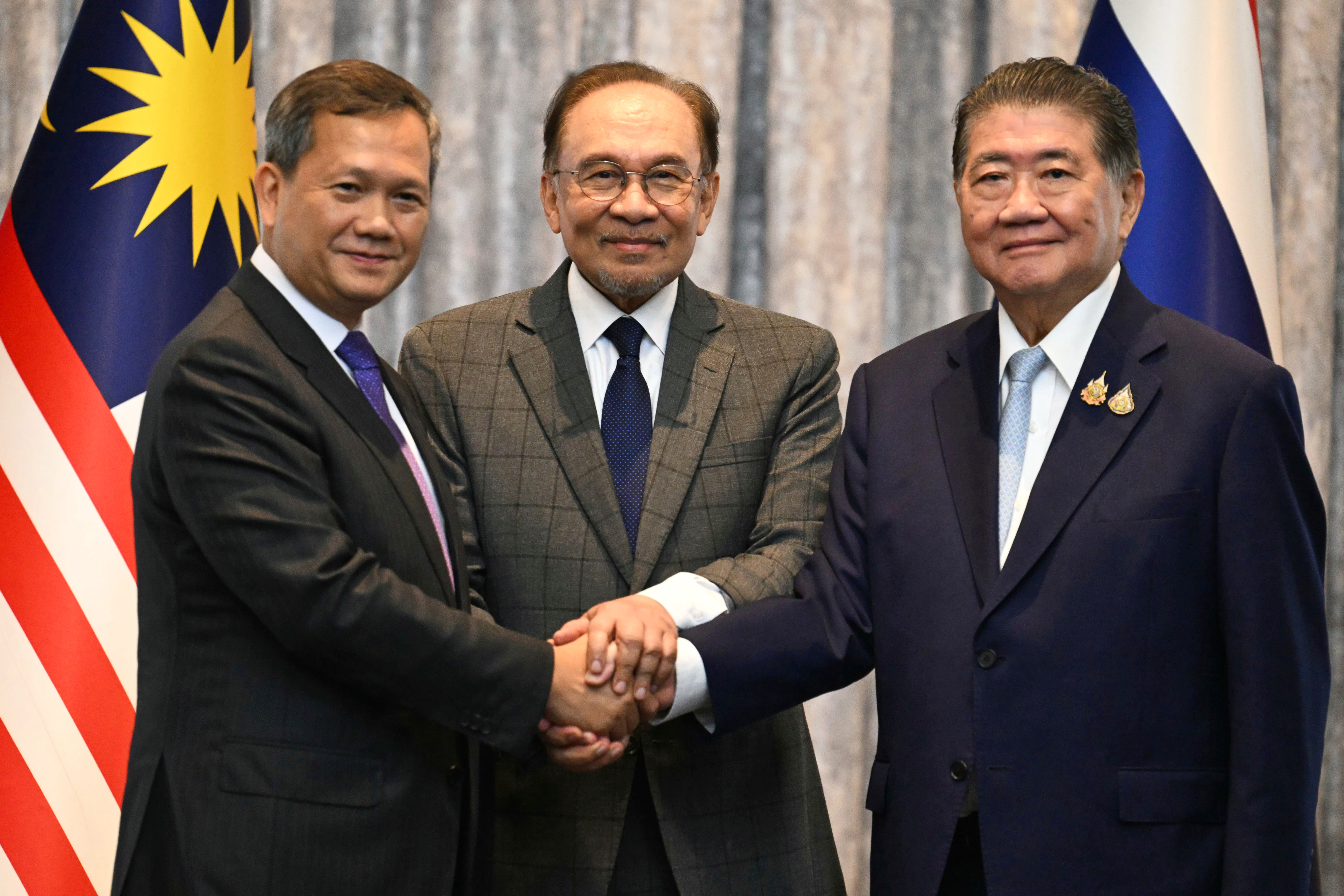 Malaysia's Prime Minister Anwar Ibrahim, center, Cambodia's Prime Minister Hun Manet left and Thailand's acting Prime Minister Phumtham Wechayachai pose for photos after talks on a possible ceasefire between Thailand and Cambodia in Putrajaya, Malaysia, Monday, July 28, 2025. (Mohd Rasfan/Pool Photo via AP)