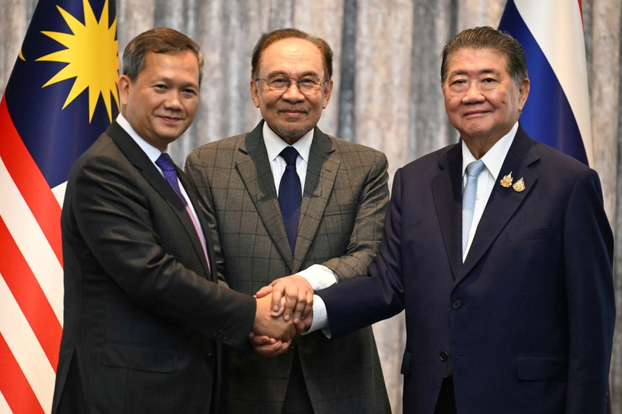 Malaysia's Prime Minister Anwar Ibrahim, center, Cambodia's Prime Minister Hun Manet left and Thailand's acting Prime Minister Phumtham Wechayachai pose for photos after talks on a possible ceasefire between Thailand and Cambodia in Putrajaya, Malaysia, Monday, July 28, 2025. (Mohd Rasfan/Pool Photo via AP)