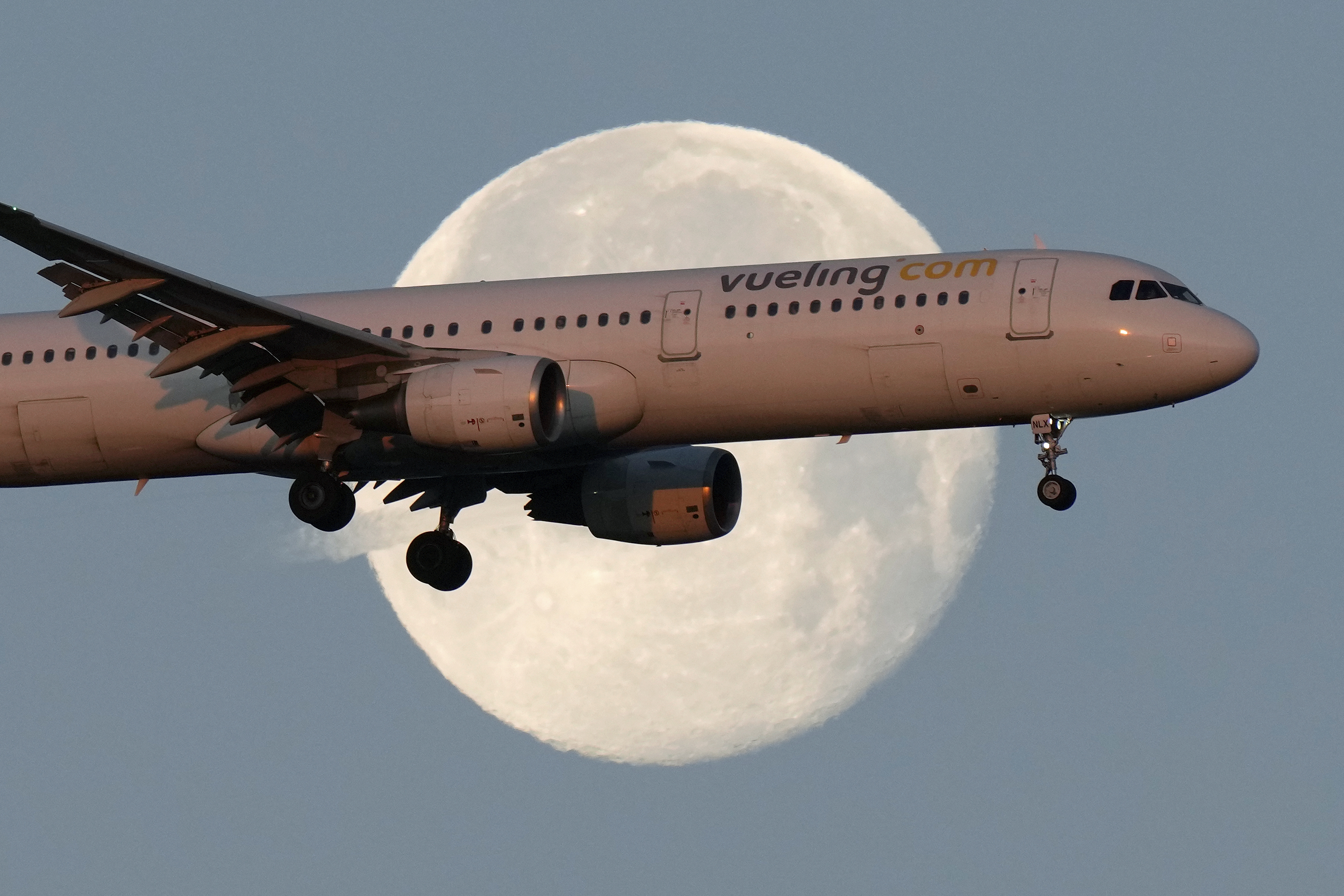 FILE - A Vueling Airbus A321 approaches for landing in Lisbon at sunrise, while the moon sets in the background,, Feb. 7, 2023. (AP Photo/Armando Franca, File)