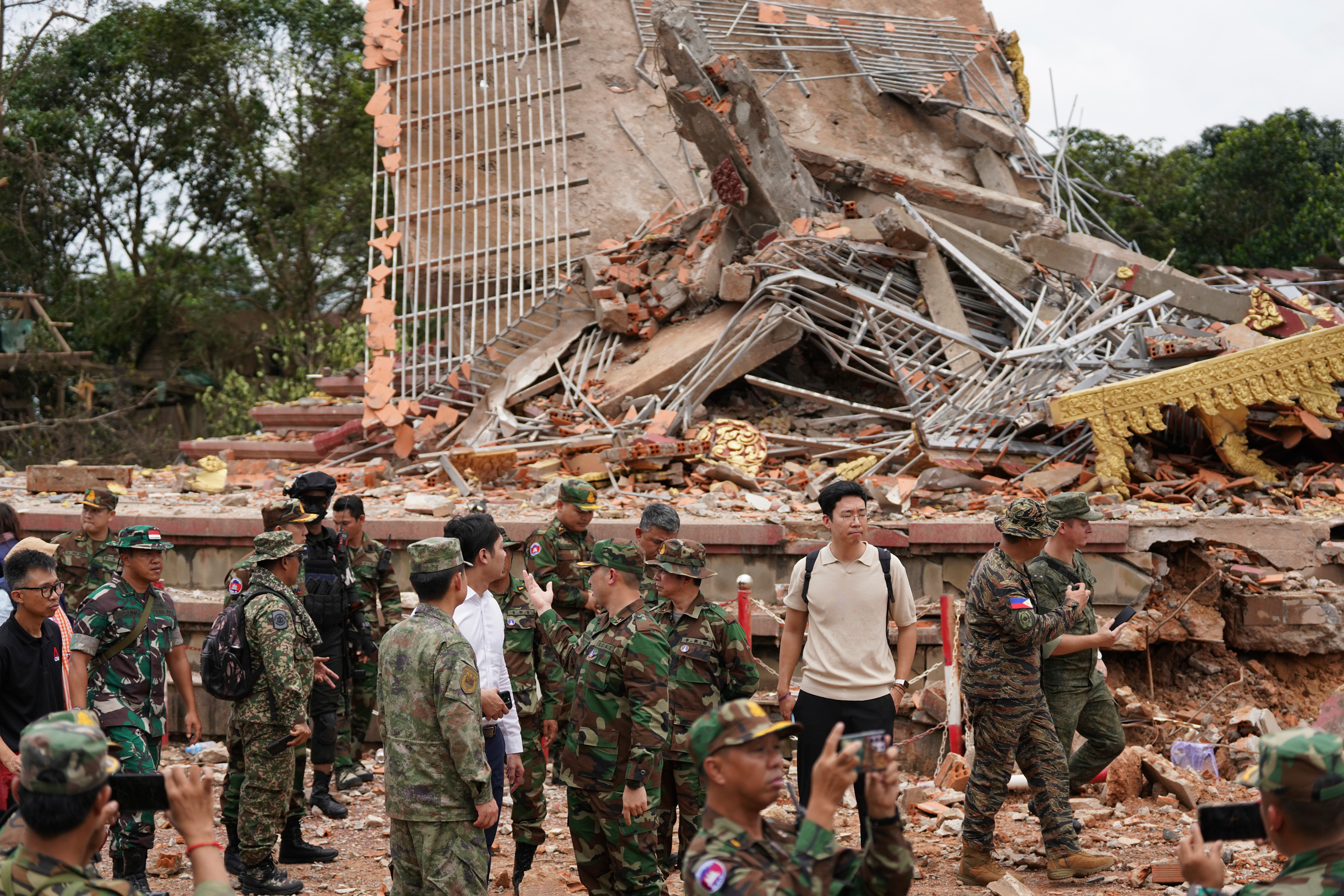 In this photo released by Agence Kampuchea Press (AKP), delegation of the military attaches and diplomats from 13 countries, including the United States and China, visit a damaged Buddhist pagoda in An Ses, a Cambodia–Thailand borders check point in Preah Vihear province, Cambodia, Wednesday, July 30, 2025, as observed the implementation of the Cambodia–Thailand ceasefire agreement. (AKP via AP)