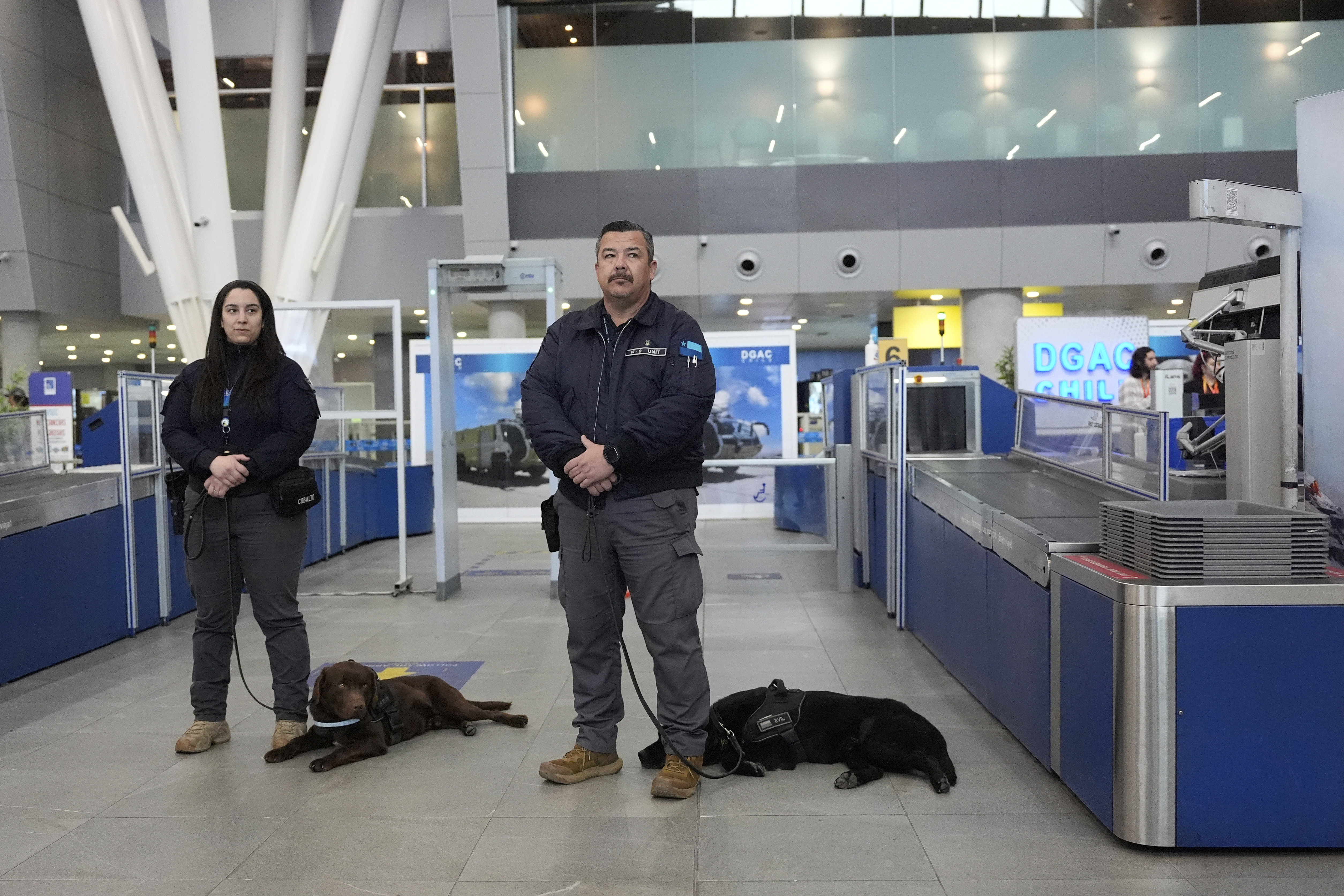 Chilean security agents stand with their sniffer dogs during a a security demonstration related to TSA screening and a Biometric Identification Transnational Migration Alert Program (BITMAP) at the Arturo Merino BenÌtez International Airport, Wednesday, July 30, 2025, in Santiago, Chile, before the departure of U.S. Homeland Security Secretary Kristi Noem. (AP Photo/Alex Brandon, Pool)