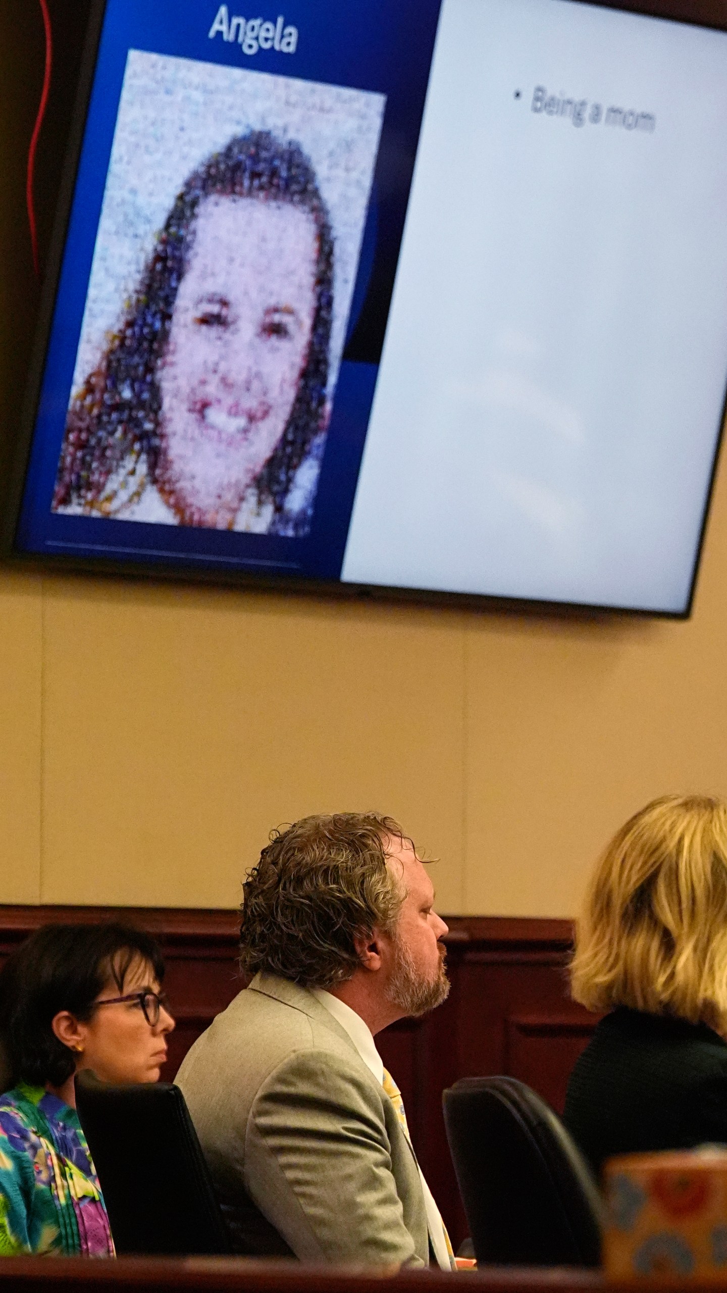 With a photograph of his wife, Angela, cast on a screen above, dentist James Craig listens during closing arguments at his murder trial in district court in Arapahoe County, Tuesday, July 29, 2025, in Centennial, Colo. (AP Photo/David Zalubowski, Pool)