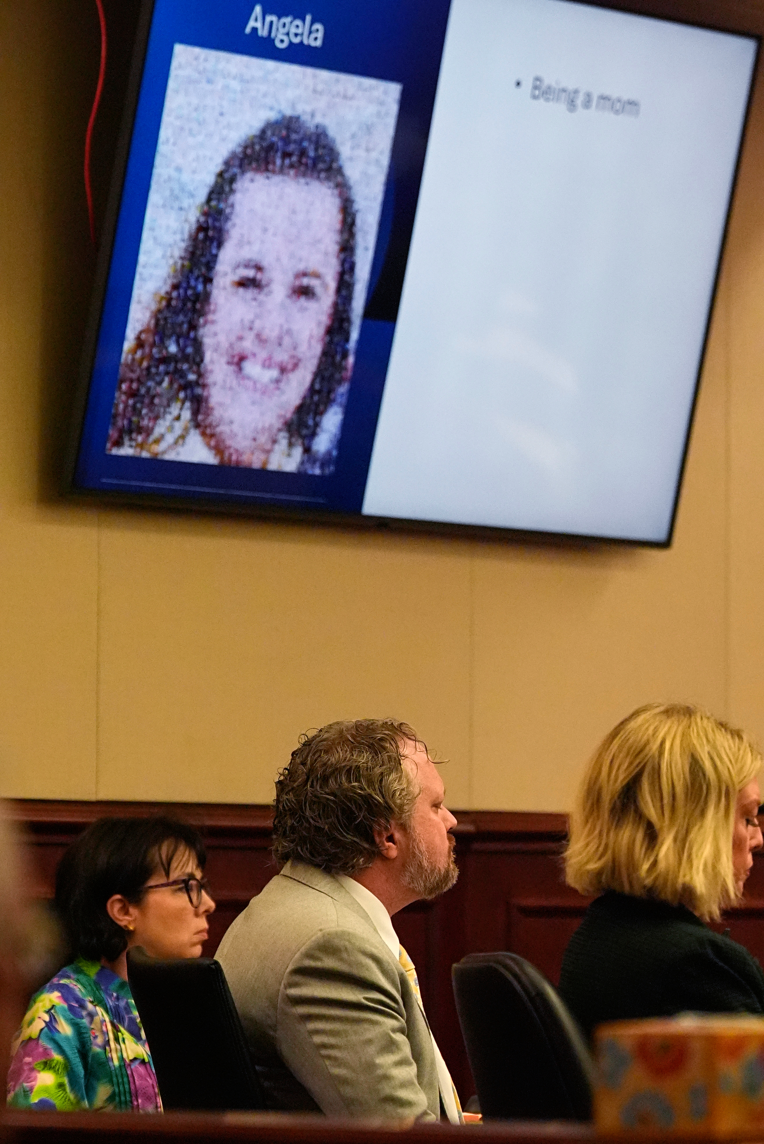 With a photograph of his wife, Angela, cast on a screen above, dentist James Craig listens during closing arguments at his murder trial in district court in Arapahoe County, Tuesday, July 29, 2025, in Centennial, Colo. (AP Photo/David Zalubowski, Pool)