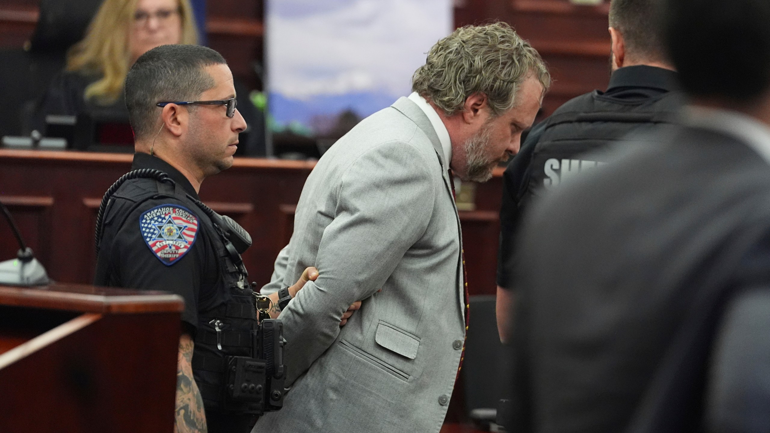Dentist James Craig, front right, is led away as Judge Shay Whitaker, back, looks on after verdict rendered in his murder trial in district court in Arapahoe County, Wednesday, July 30, 2025, in Centennial, Colo. (AP Photo/David Zalubowski, Pool)