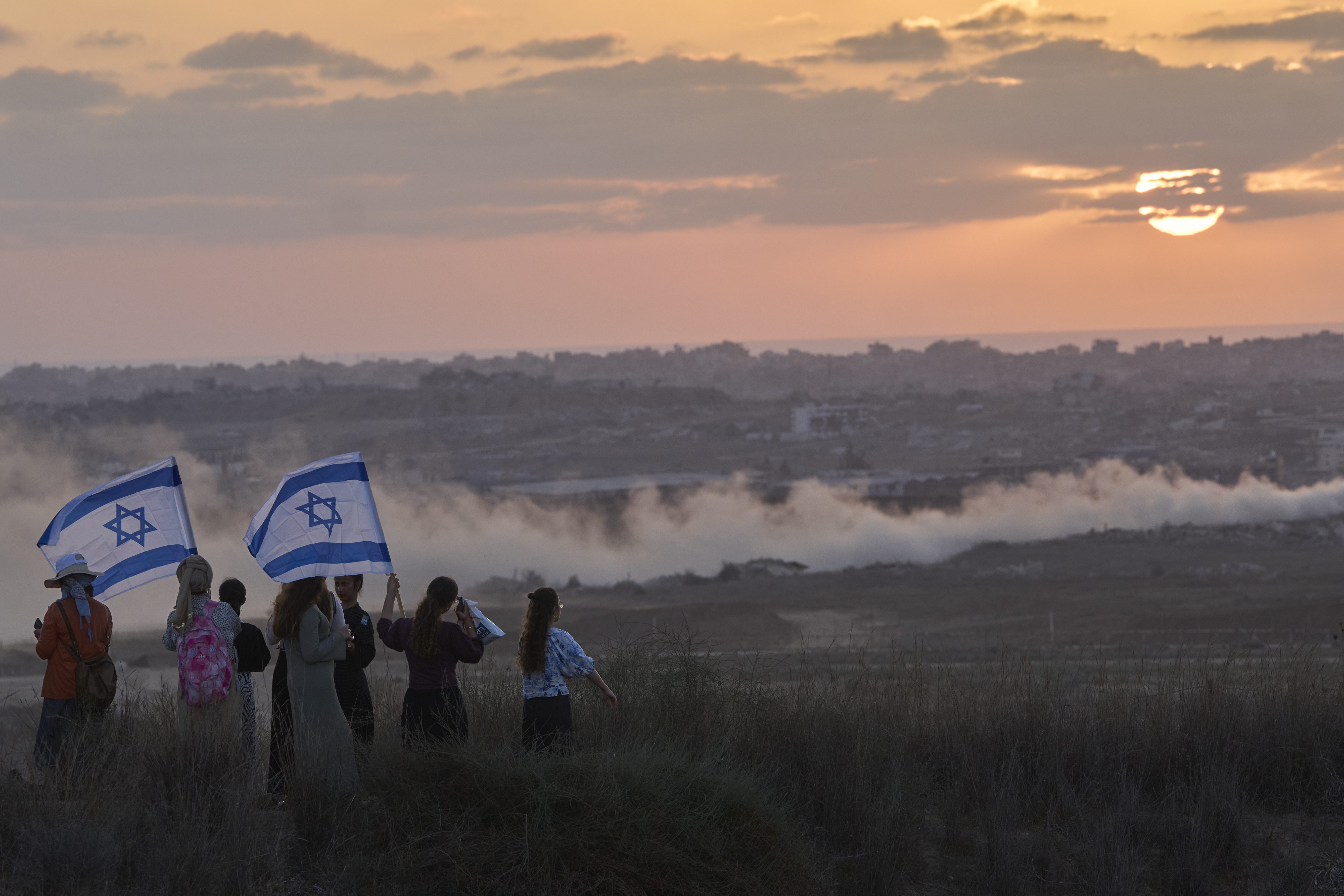 Israeli right-wing activists watch the northern Gaza Strip during a rally calling for the re-establishment of Jewish settlements in the Gaza Strip, near the border in southern Israel, Wednesday, July 30, 2025. (AP Photo/Ohad Zwigenberg)